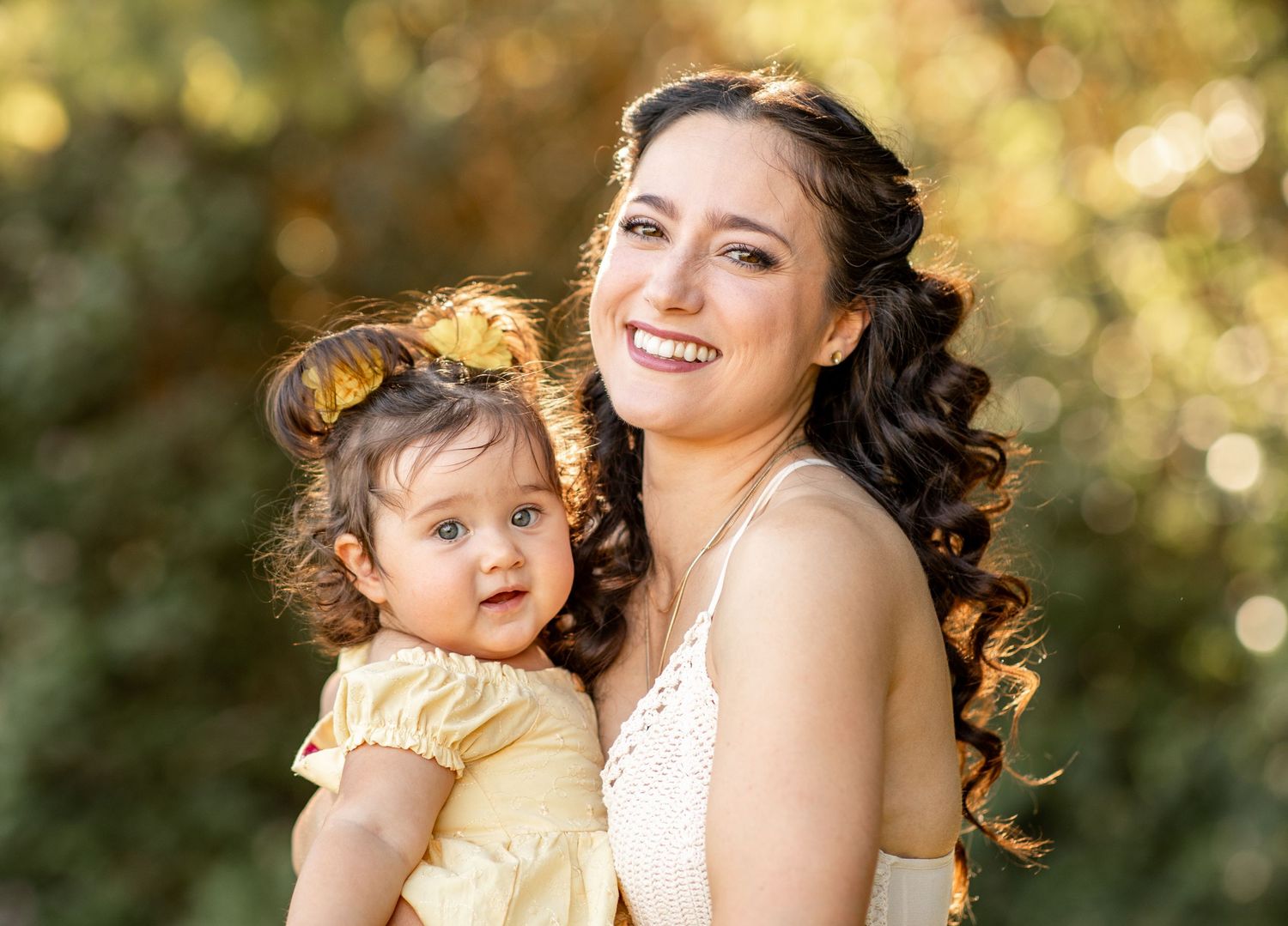 Mother and daughter share tender moments outdoors in golden sunlight during photo session at The Meadow in Mesa.