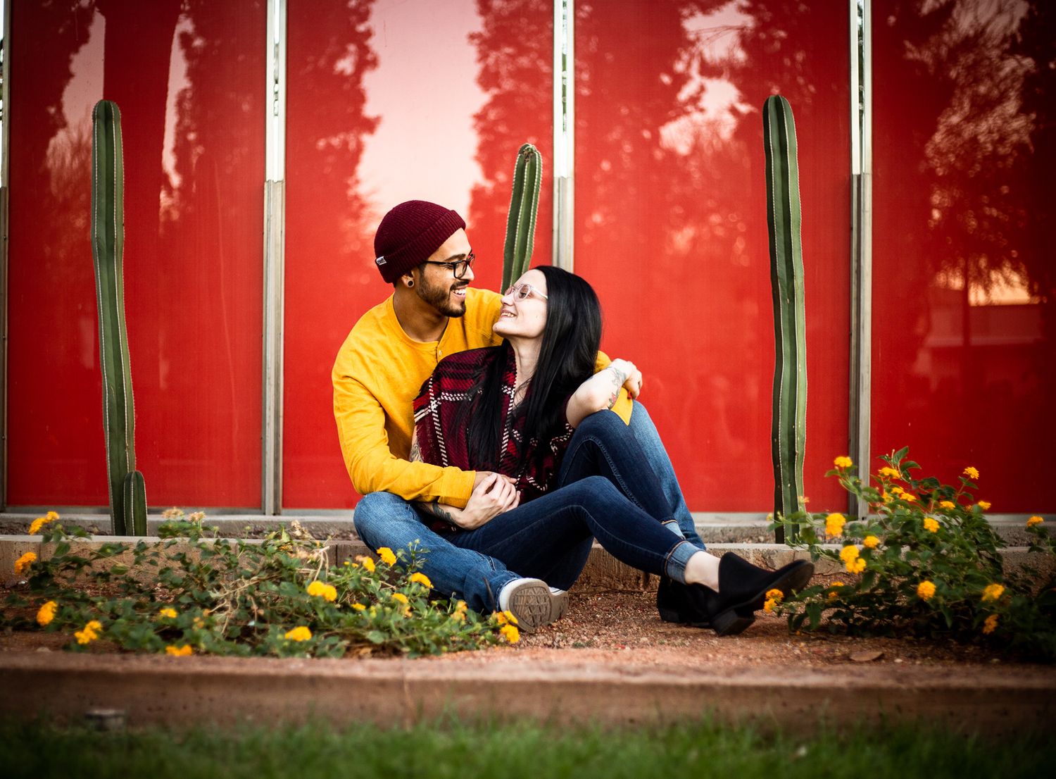 Romantic couple relaxing by red wall with yellow and green accents at the Mesa Arts Center in Mesa, Arizona.
