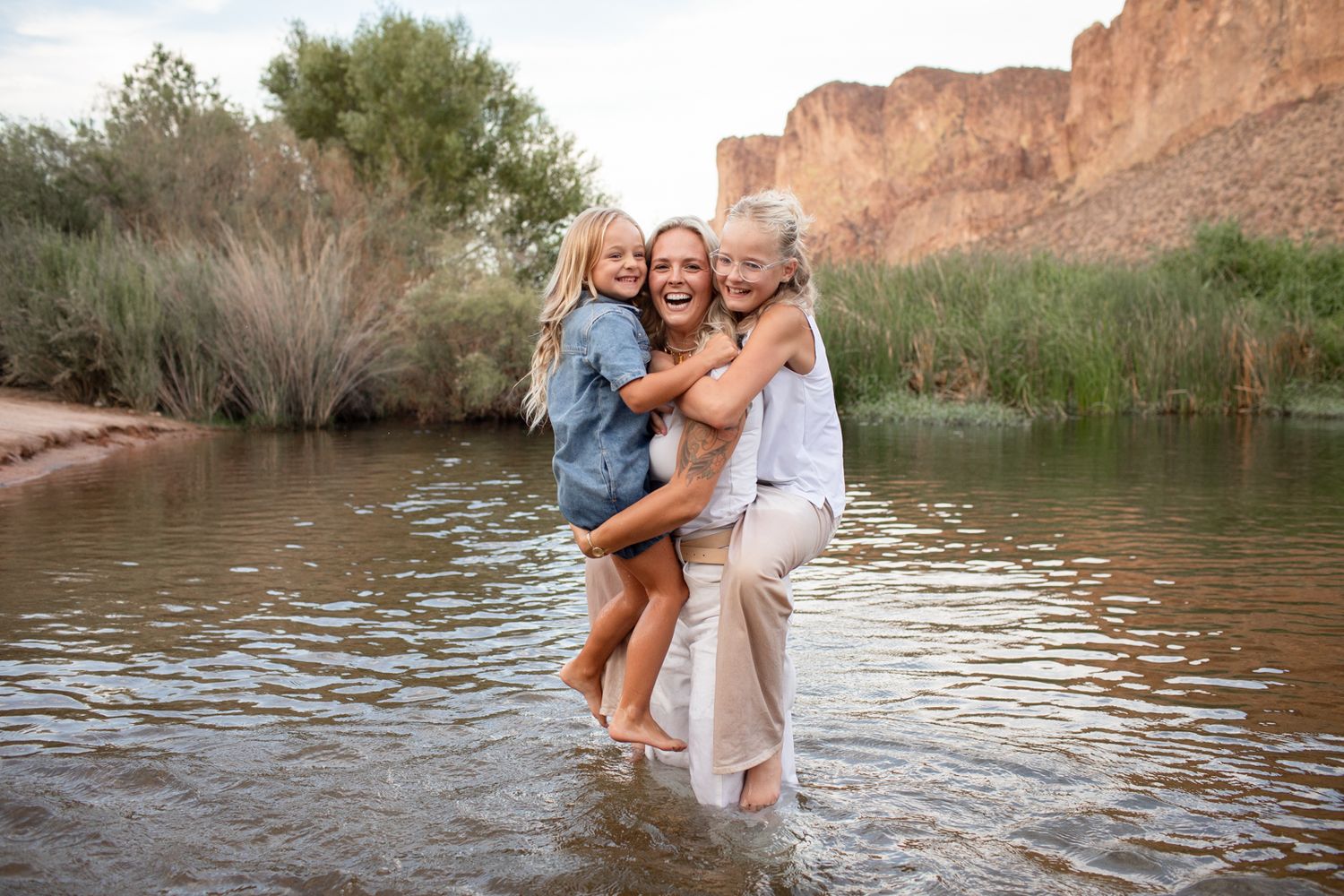 People enjoying a sunny day splashing and playing in a scenic desert river surrounded by red rock canyon walls at Water Users.