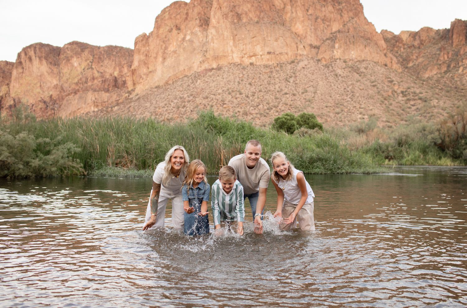 Group enjoying a fun splash in shallow water near rocky cliffs during a sunny outdoor adventure at Water Users recreational area.