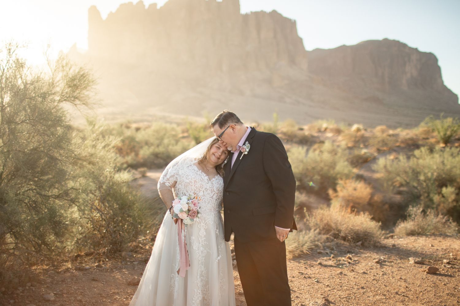 Desert wedding photography sequence showing tender moments between newlyweds in front of the superstition mountains in Arizona.