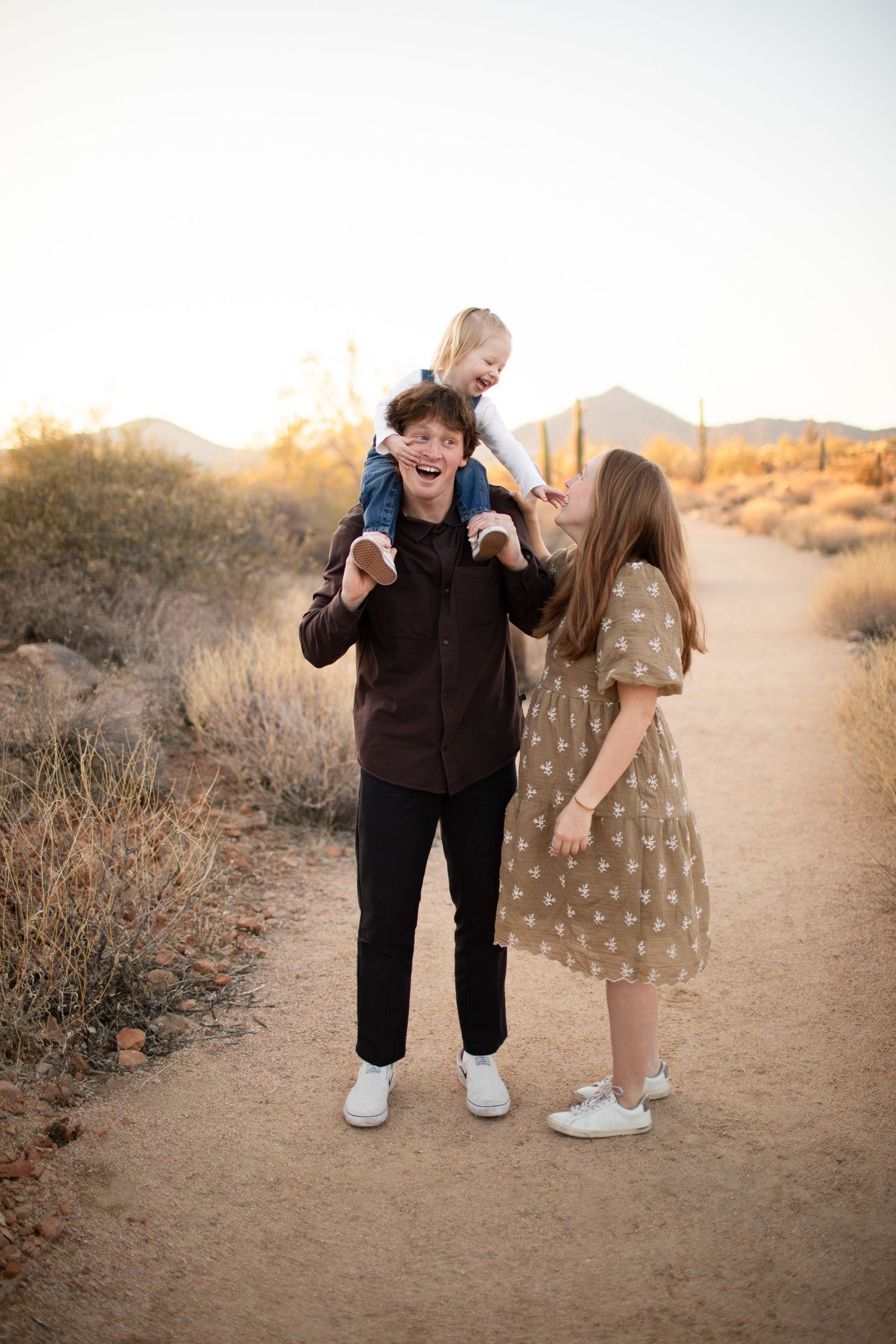 Two people share a joyful moment together on a desert trail during golden hour at sunset at Usery Pass in Mesa, Arizona.