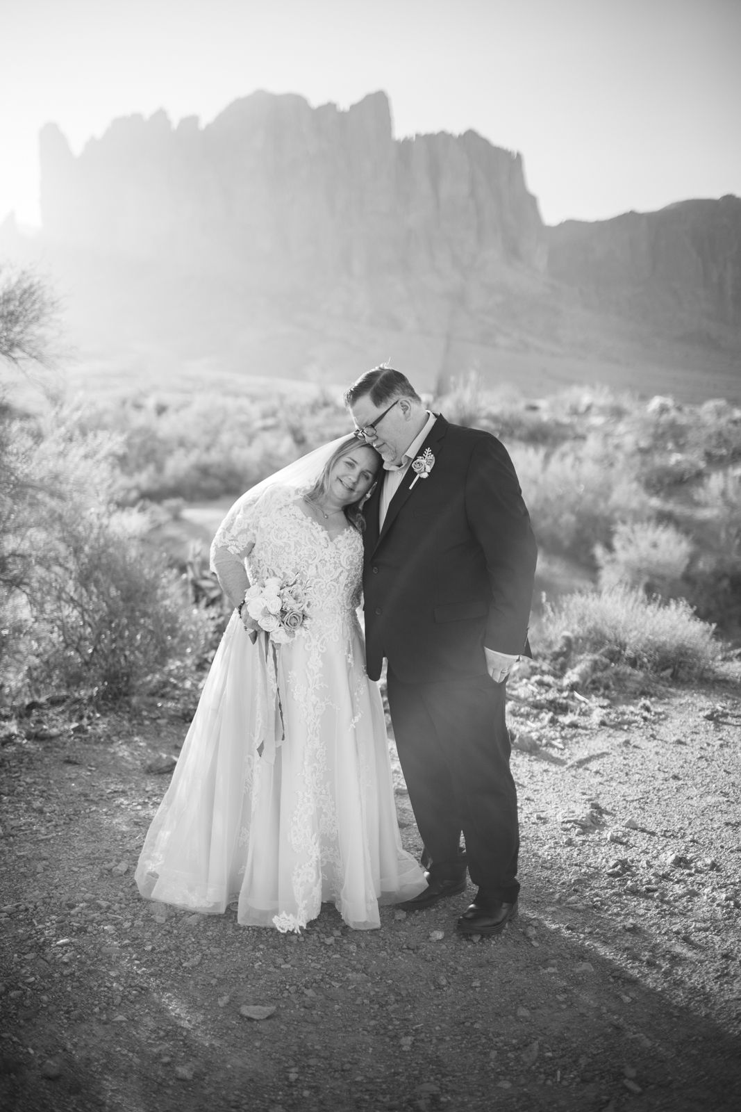 Black and white wedding photos capturing intimate moments in a desert landscape in front of the Superstion Mountains in Arizona.