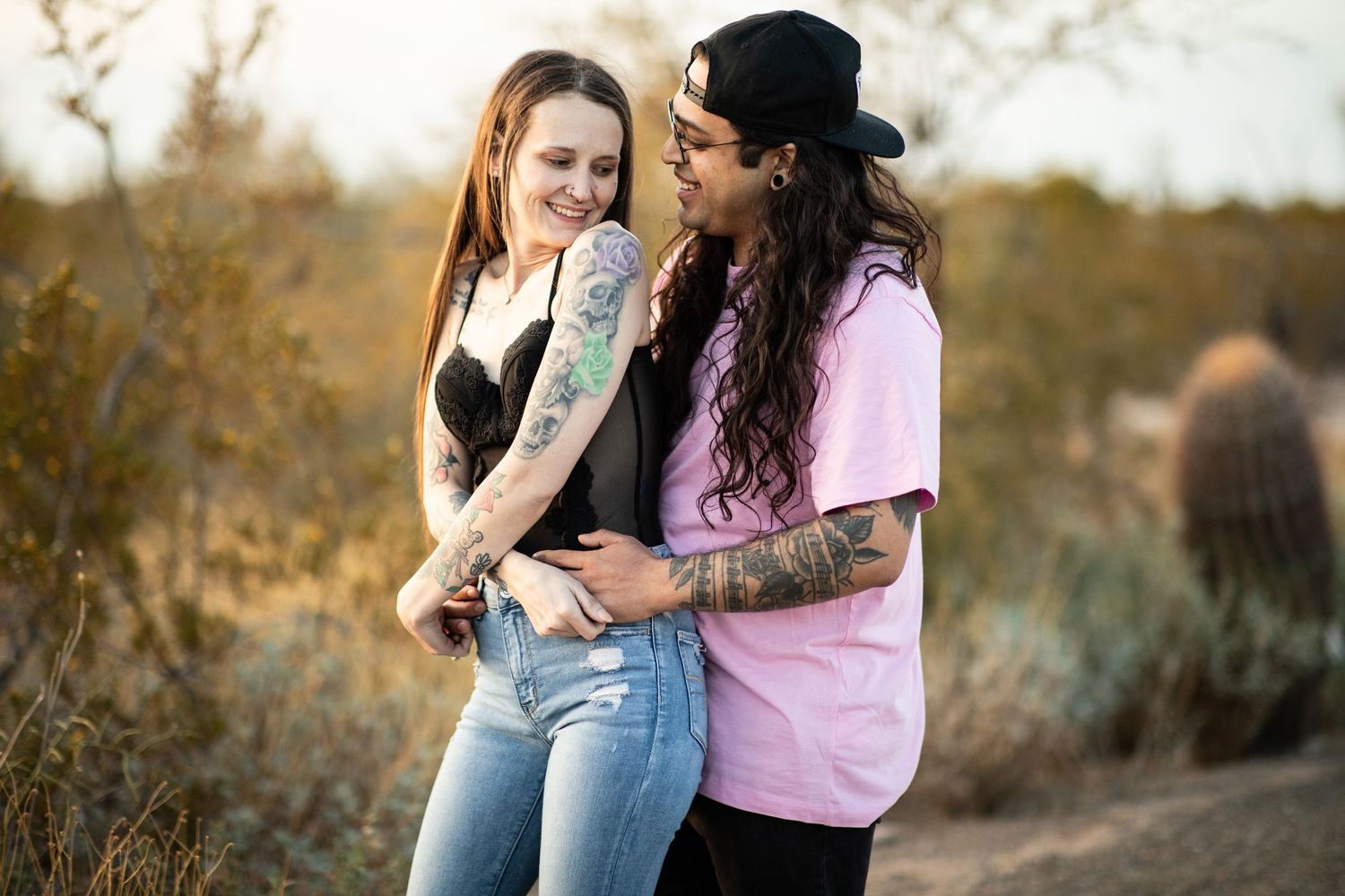 A romantic couple embraces during a golden hour photoshoot in a natural outdoor setting at Desert Arroyo Park in Mesa, Arizona.