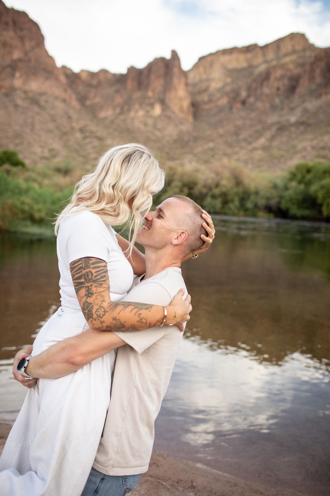 A romantic embrace captured by the water with dramatic desert cliffs in the background at Water Users recreational area.