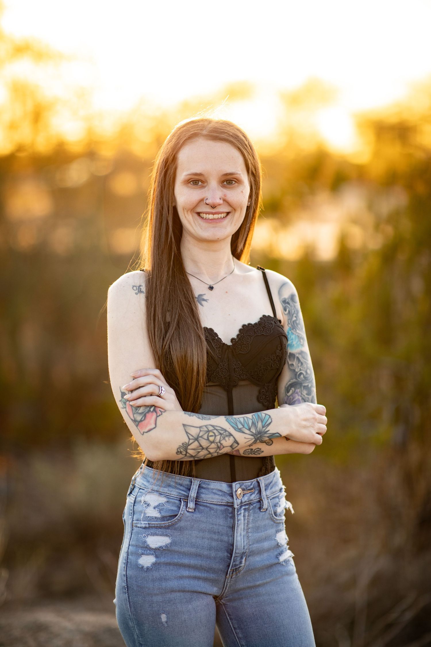 Person in black top and distressed jeans posing outdoors during golden hour at Desert Arroyo park in Mesa, Arizona