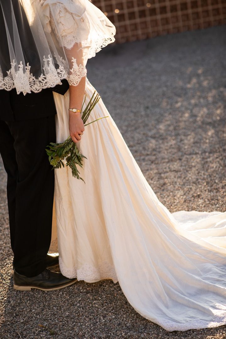 Detail shots of an elegant white wedding dress train on textured ground at Desert Studio AZ.