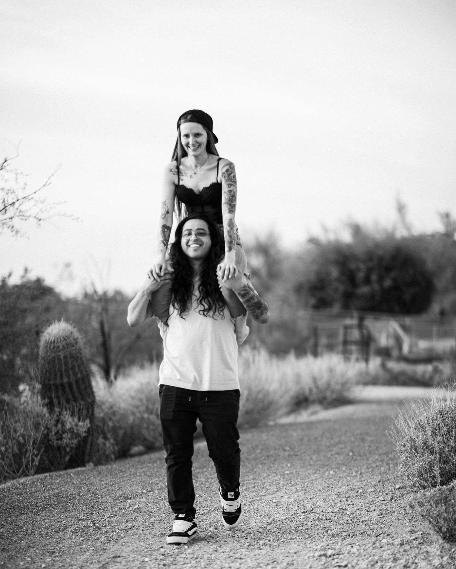 Black and white sequence of photos showing a couple running along a path at Desert Arroyo Park in Mesa, Arizona.