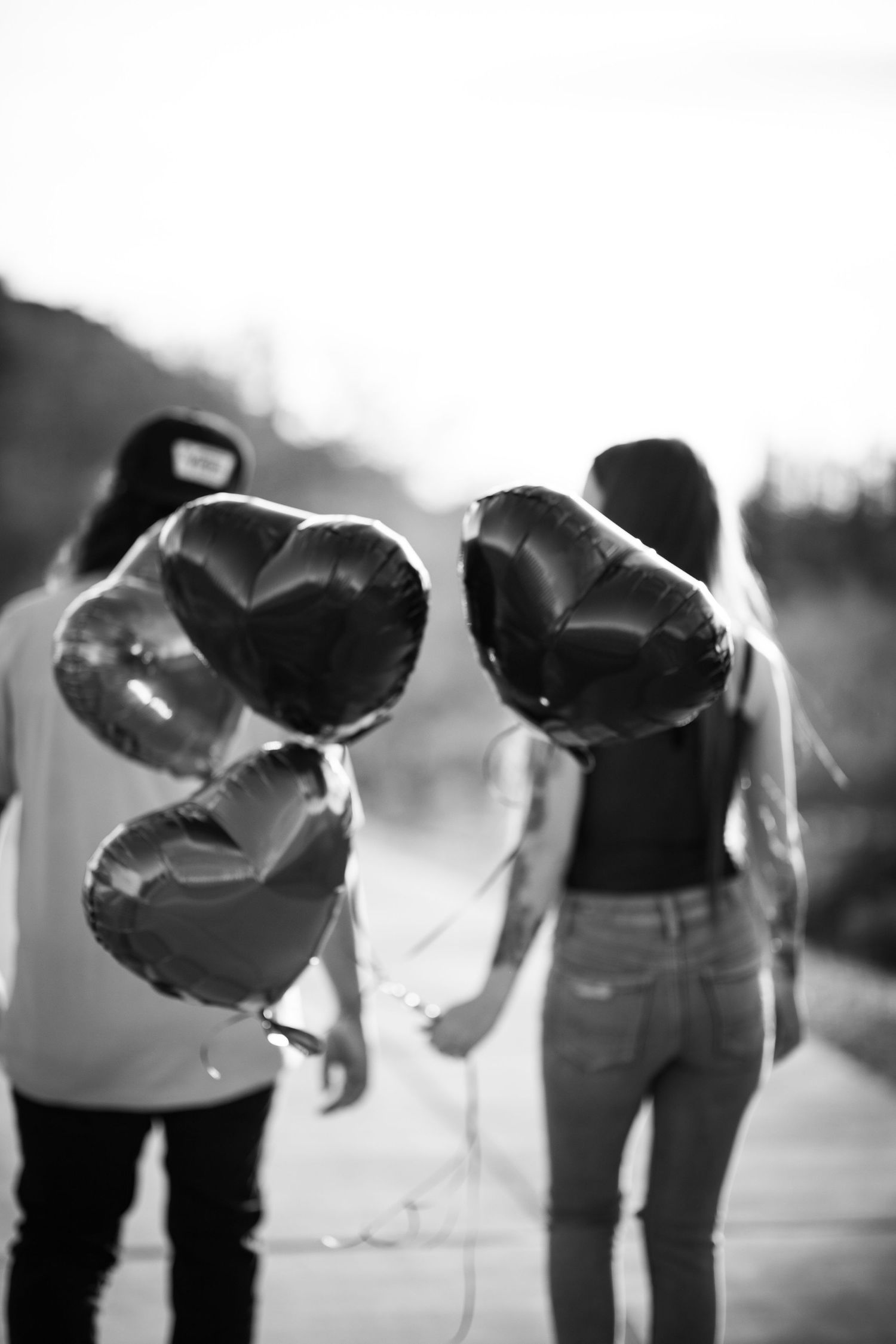 A black and white artistic photo shows people bending down to look at something on the ground at Desert Arroyo Park in Mesa, Arizona