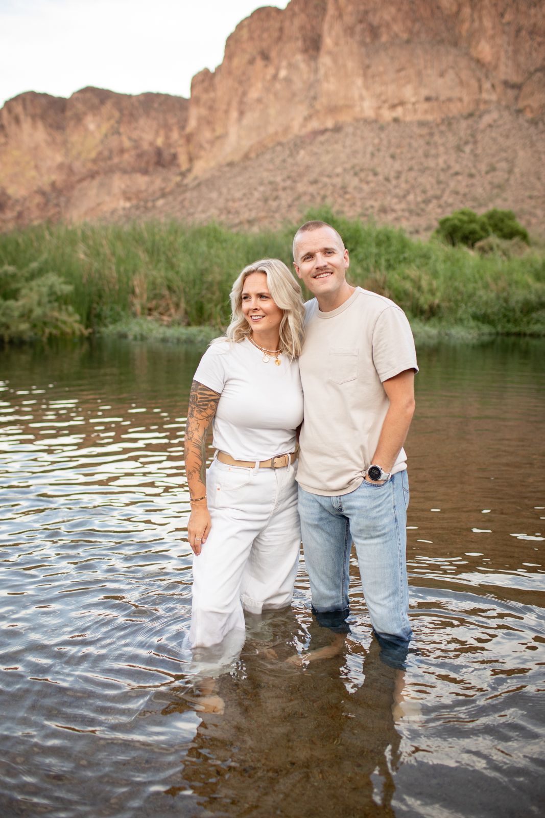 Couple wading together in river water with desert mountains creating a stunning natural backdrop at Water Users recreational area.