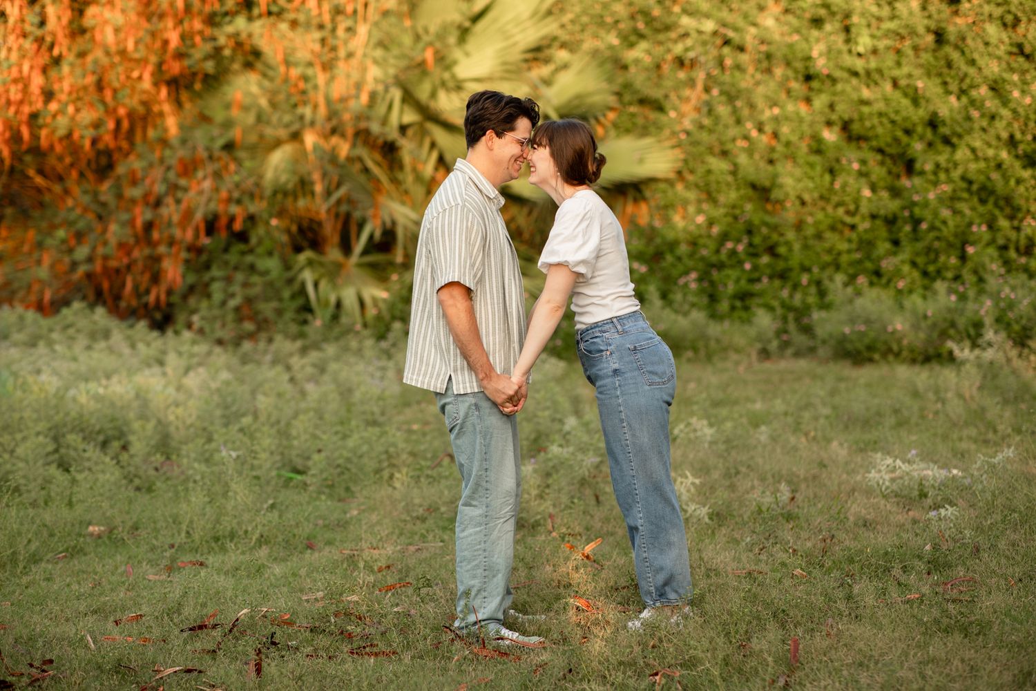 A romantic couple sharing an intimate moment in a natural outdoor setting during sunrise at The Meadow in Mesa, Arizona.