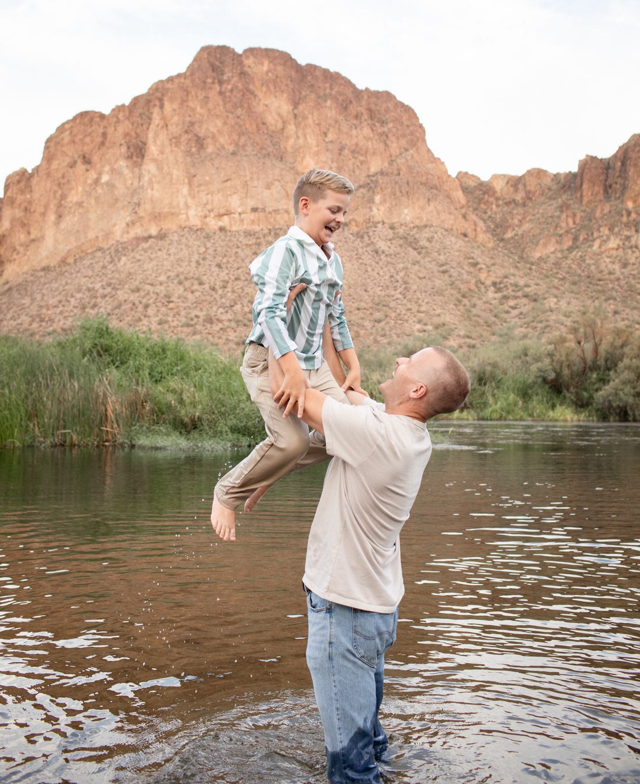Joyful interactions in shallow water with scenic desert canyon walls rising in the background at Water Users recreational area.