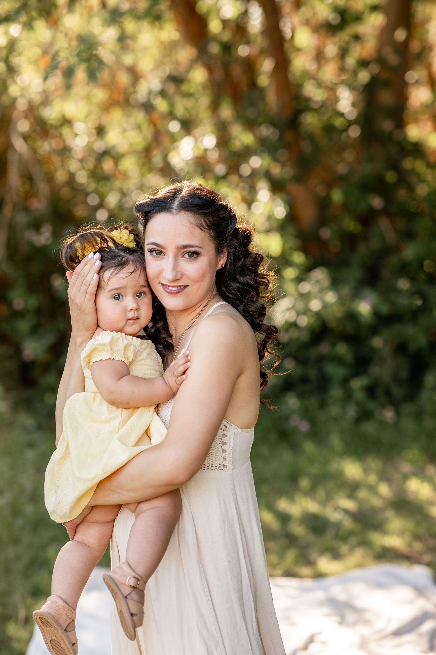 A sweet outdoor portrait session showing a parent and child in cream-colored outfits against a natural garden backdrop at The Meadow in Mesa