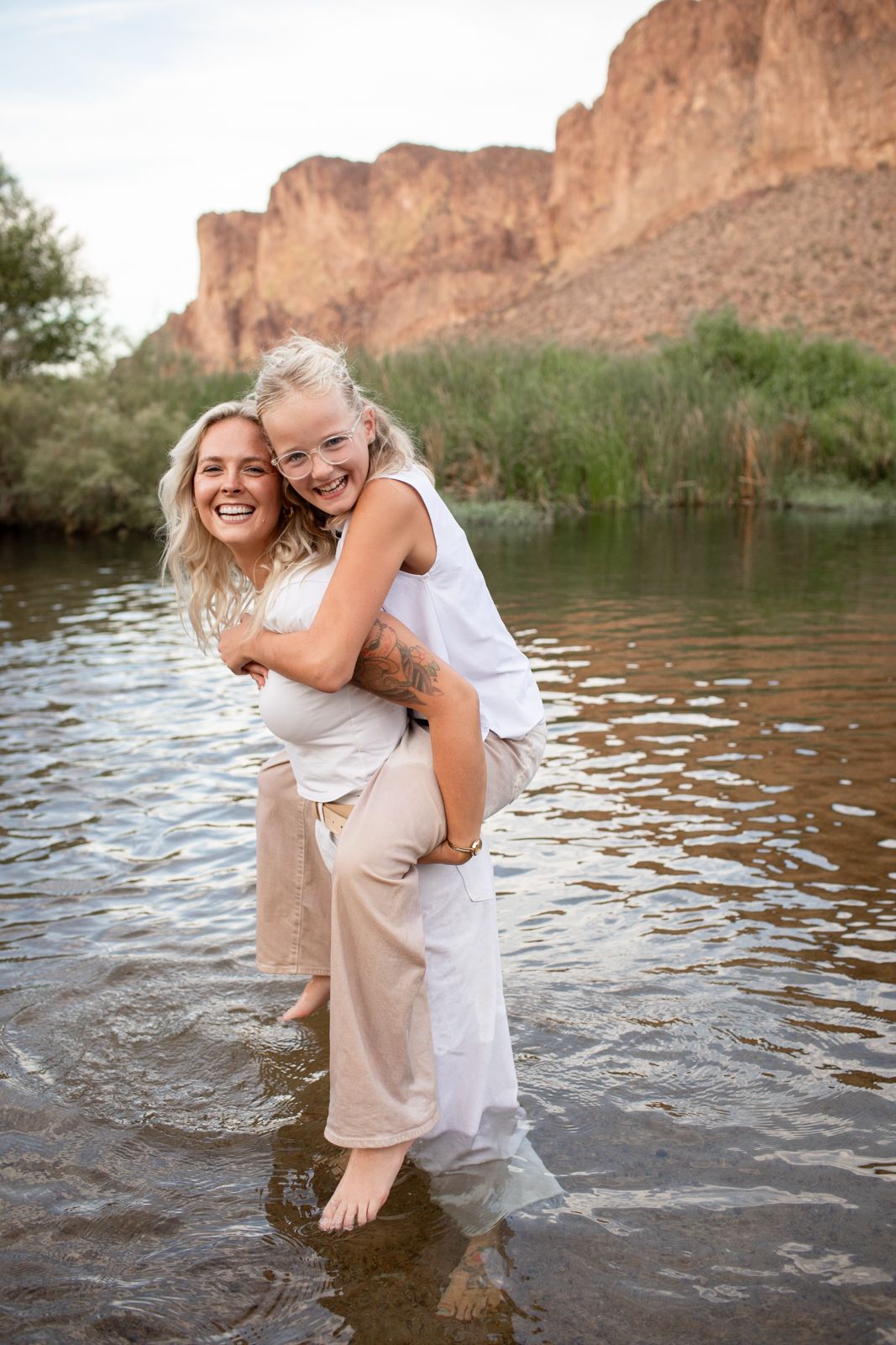 A playful moment captured in a river with rugged desert cliffs and mountains in the background at Water Users recreational area.