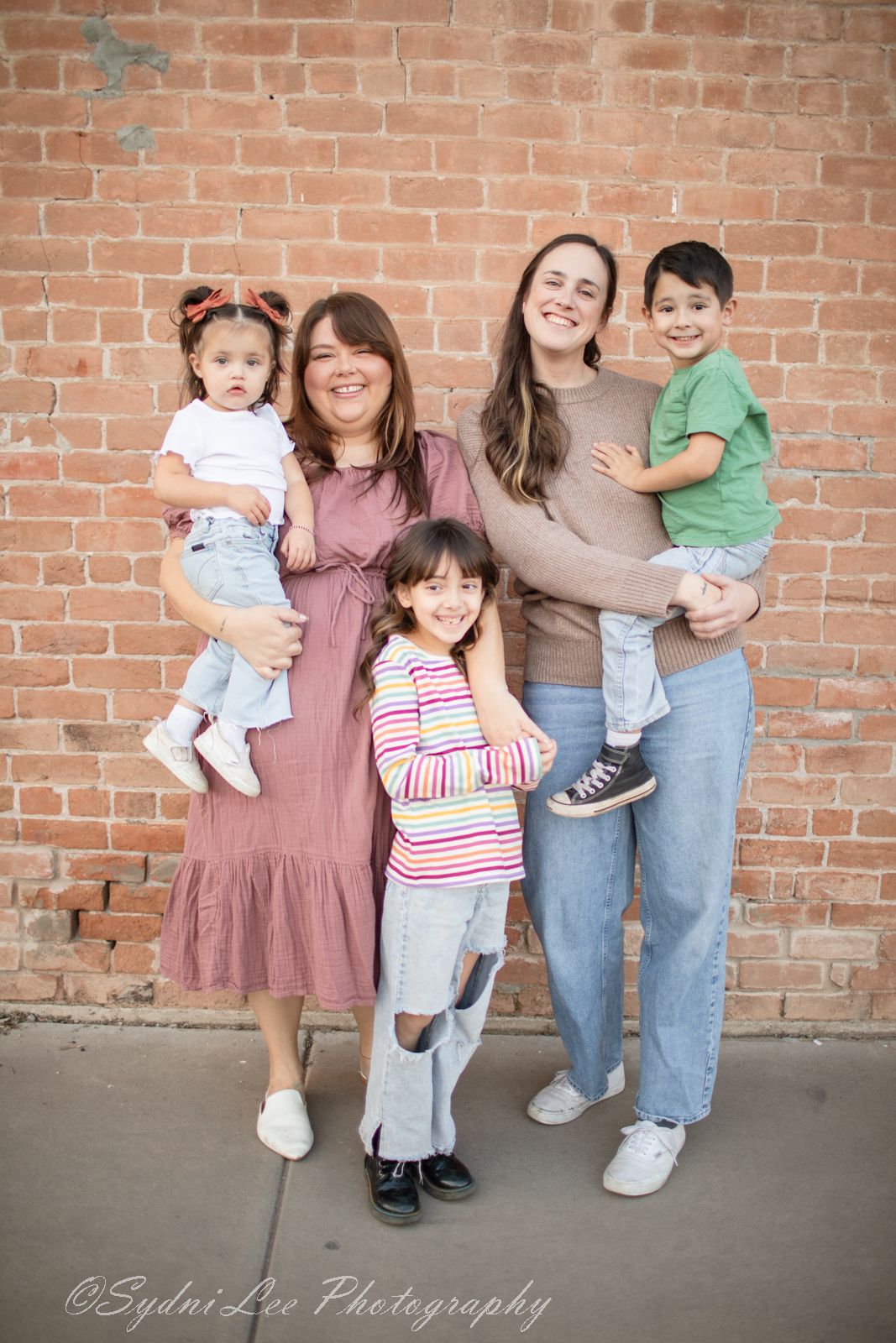 Three progressive photos showing a family group posing casually against a brick wall background in downtown Mesa, Arizona.