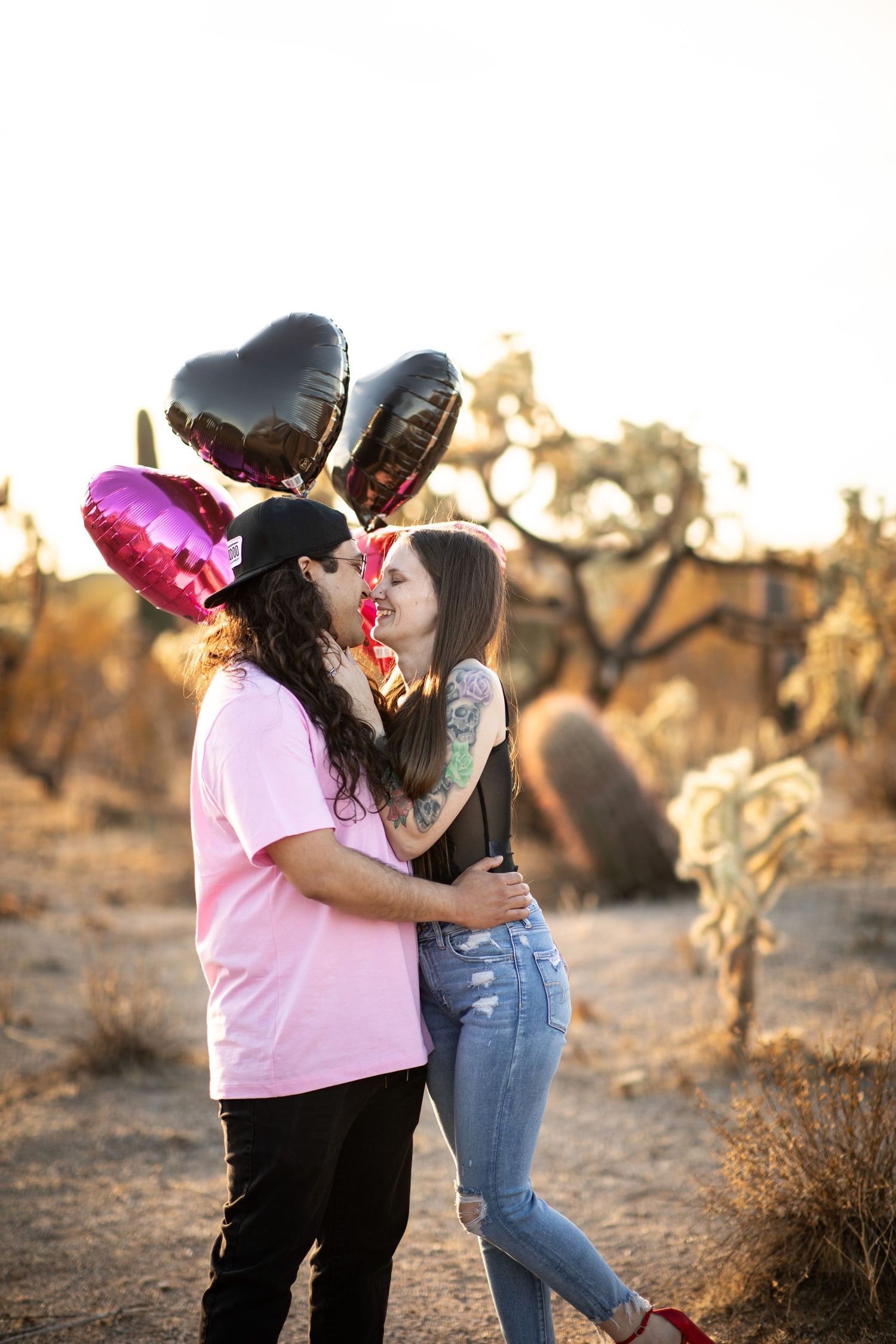 A couple embraces in a desert landscape during golden hour at Desert Arroyo Park in Mesa, Arizona.