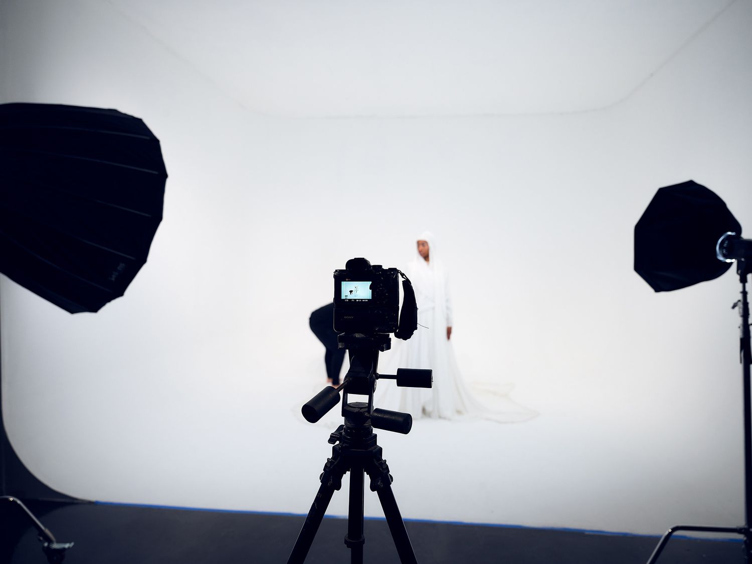 Silhouetted photography equipment and light modifiers in a professional studio setting.