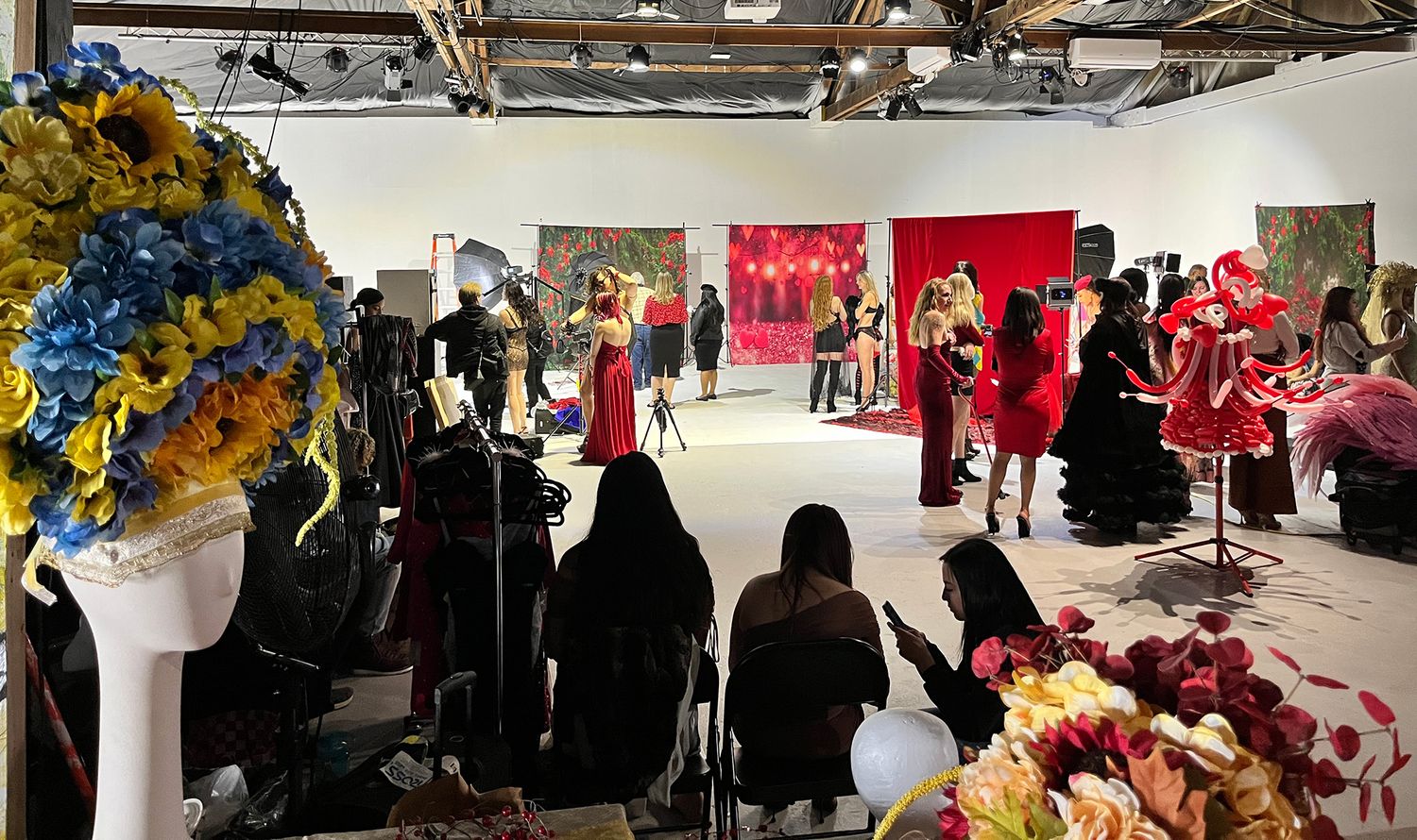 Behind-the-scenes view of a studio photoshoot setup with lighting equipment and crew members.