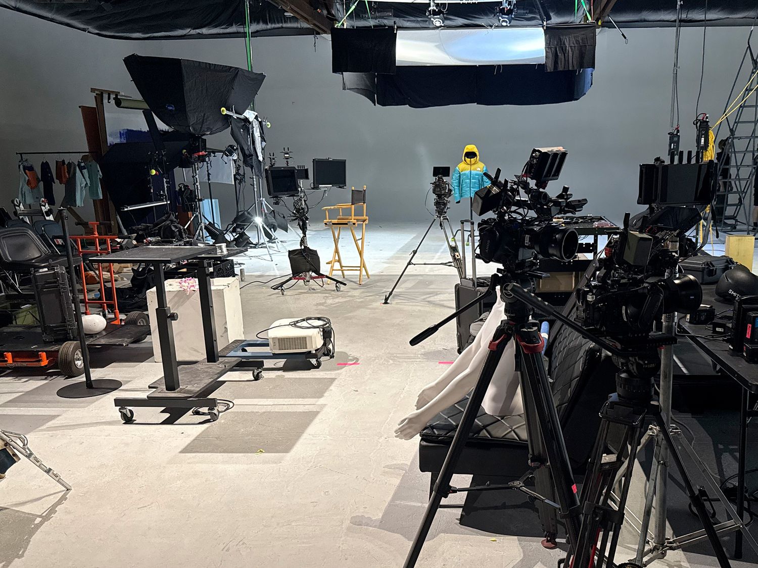 Professional broadcast studio setup with multiple cameras, lighting rigs, and production equipment arranged in a television studio.