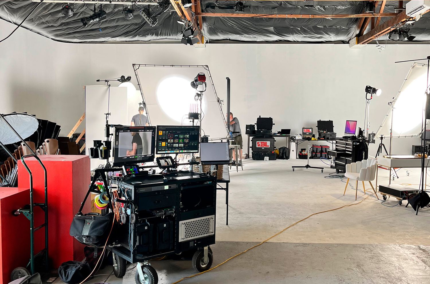 Wide panoramic view of an empty studio space with professional photography equipment setup.