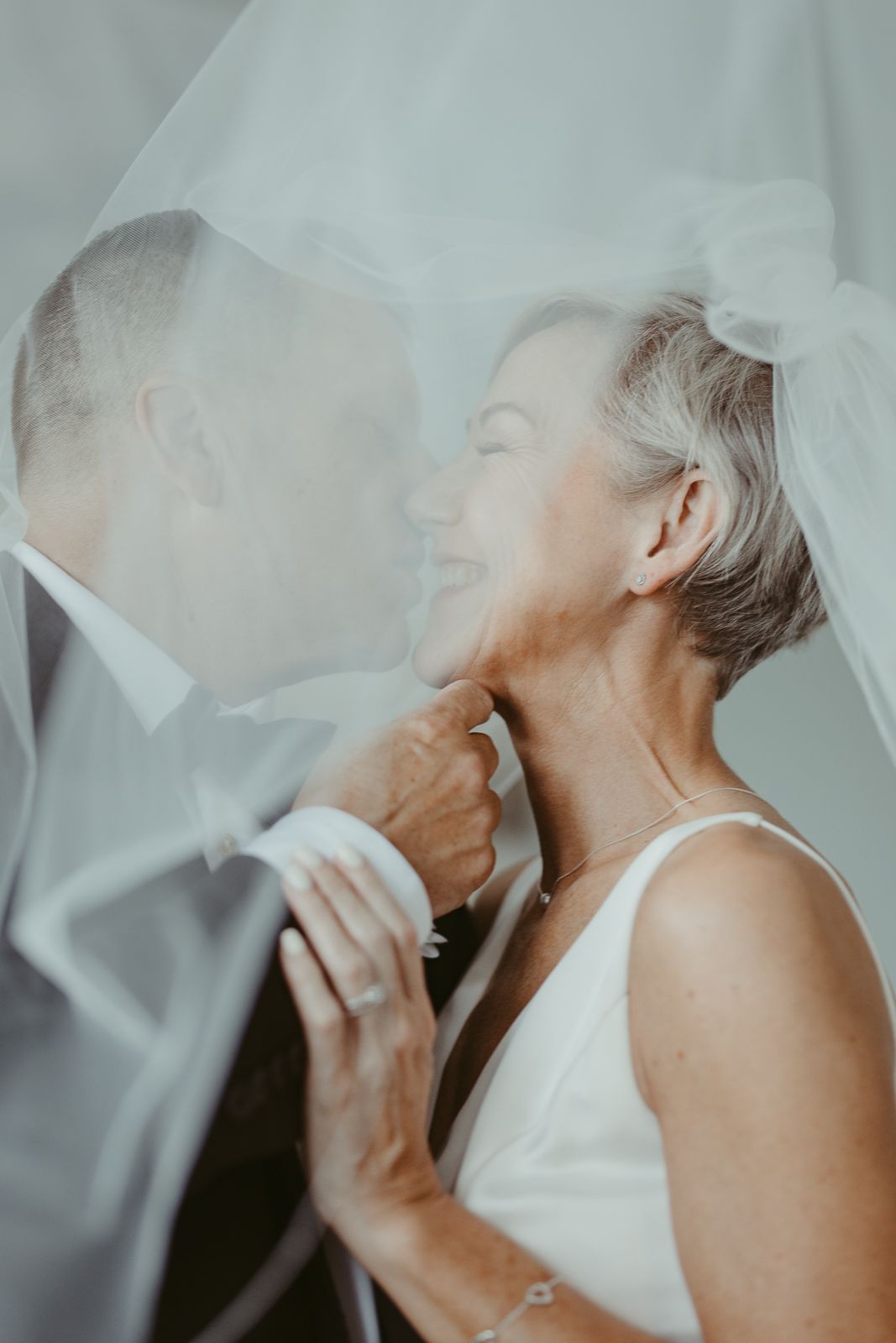 An intimate moment between newlyweds captured through a delicate veil.