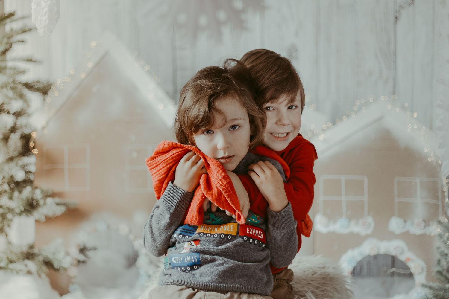 A sweet moment captured between two figures with soft lighting and nostalgic warmth against a textured wall background.