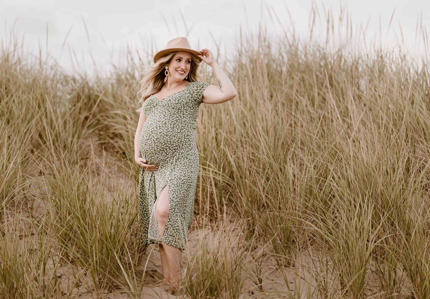 Couple poses together in rustic field setting for maternity photography session.