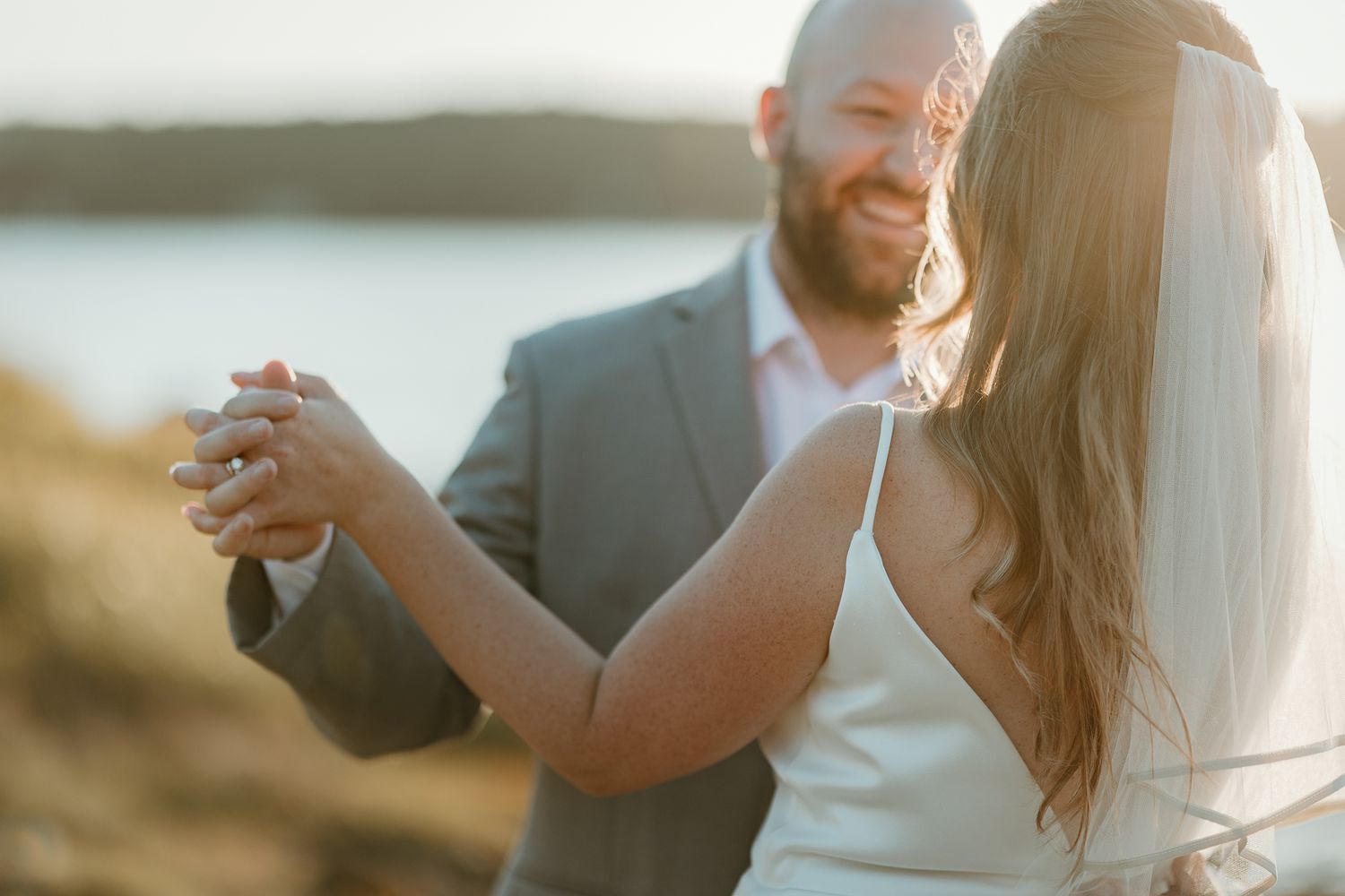 A couple dances together in soft golden light during their wedding photoshoot.