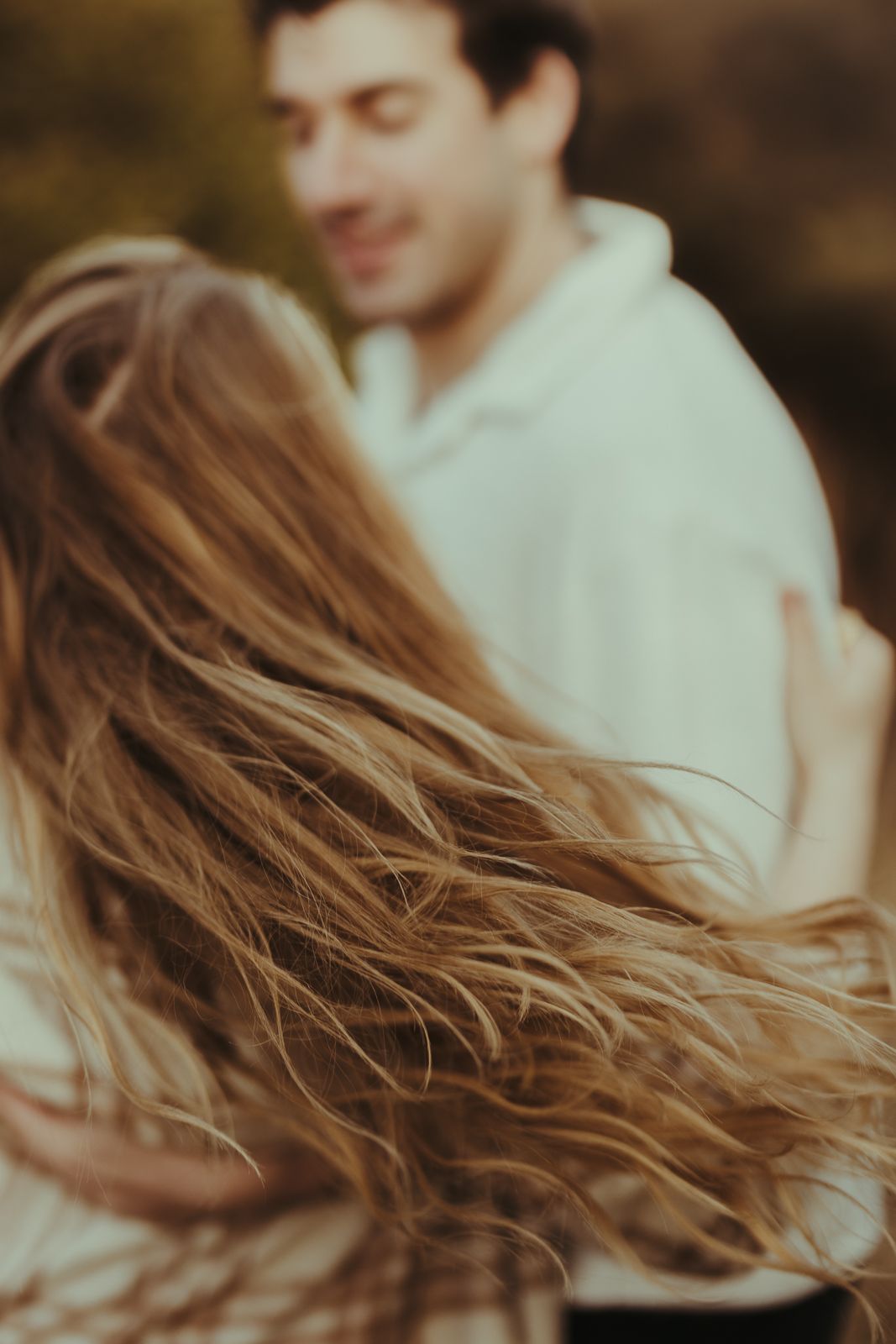 Close-up view of flowing brown hair against a soft blurred background.