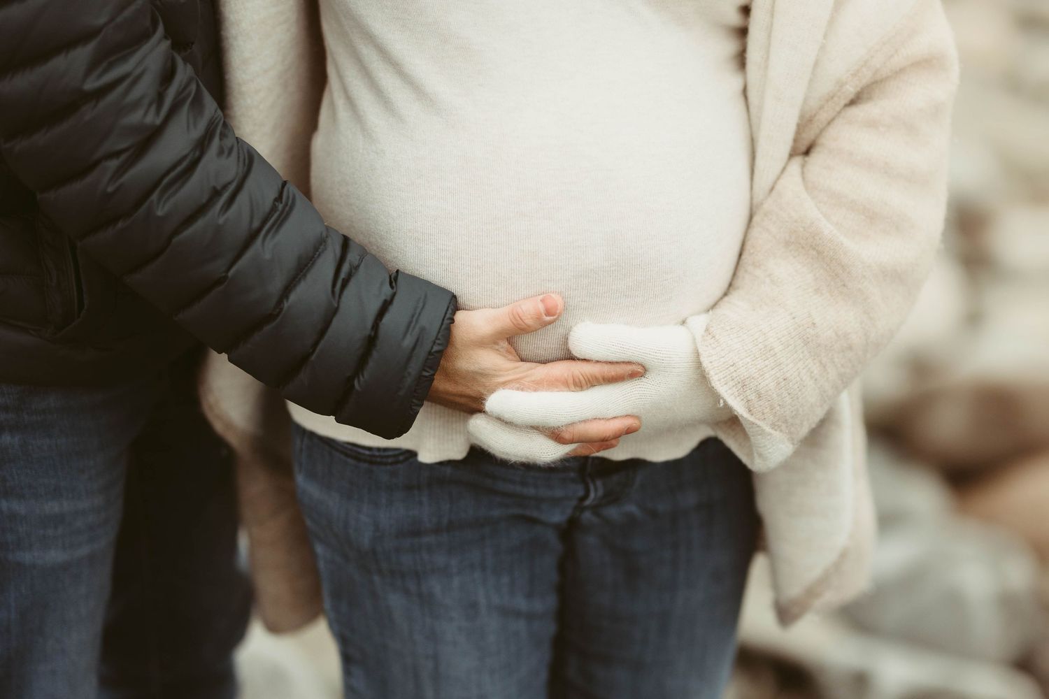 A close-up shot of an expectant couple embracing during their maternity photo session.