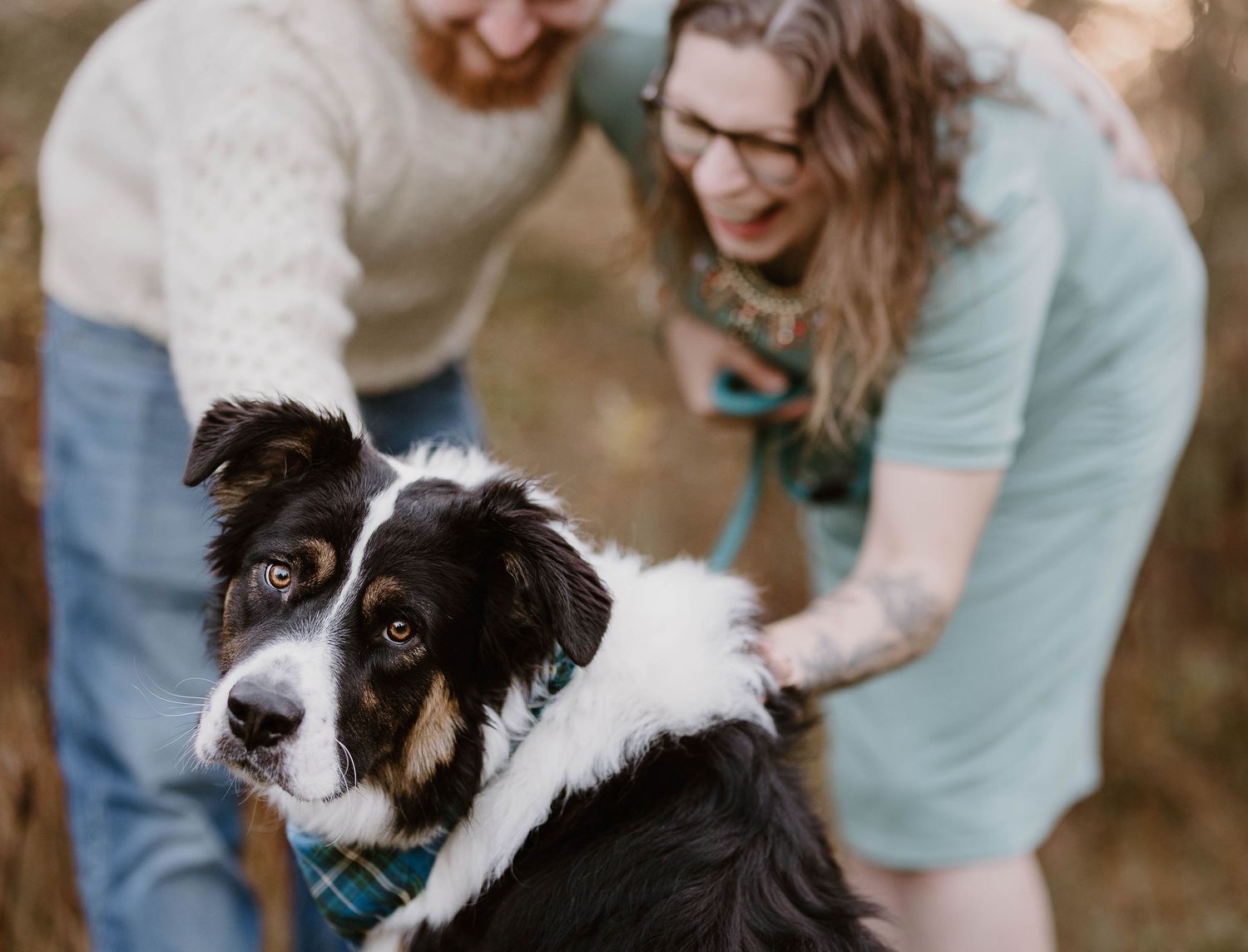 A dog and owner share a tender moment outdoors during a photo session in natural lighting.