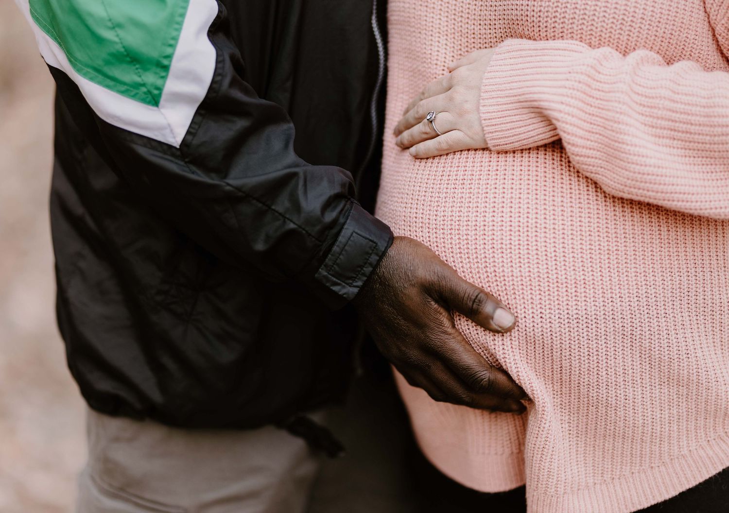 Close up shot of a couple embracing with pink and green clothing details.