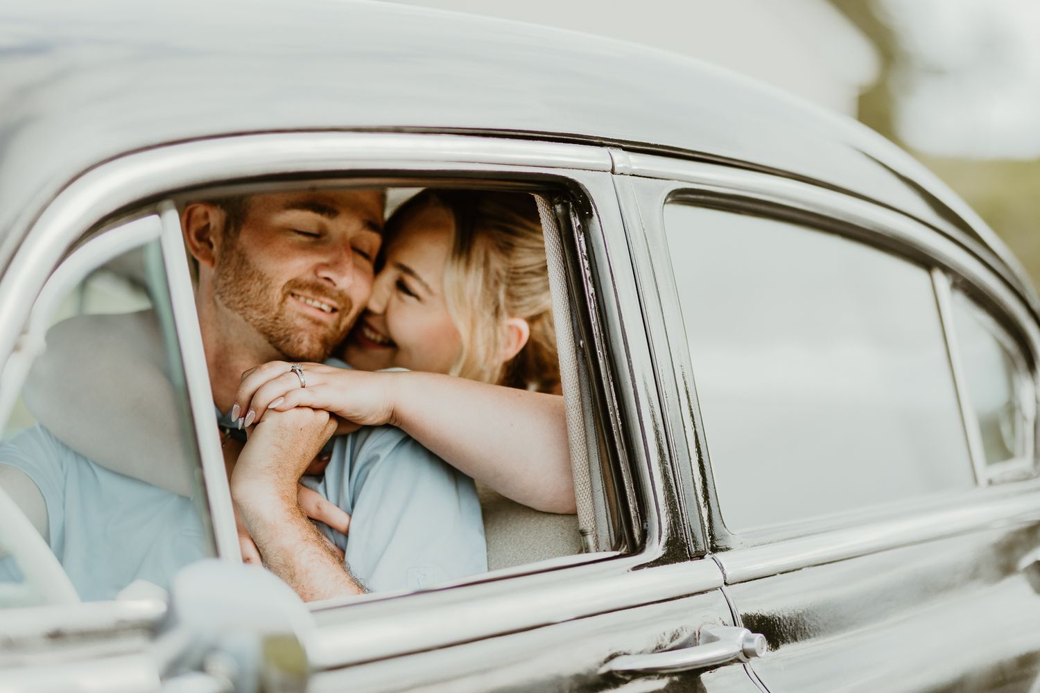 Intimate moments captured inside a vintage car with soft lighting and romantic atmosphere.