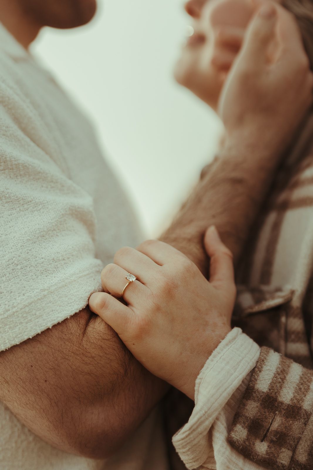 Close-up of hands with engagement ring in intimate gentle poses.