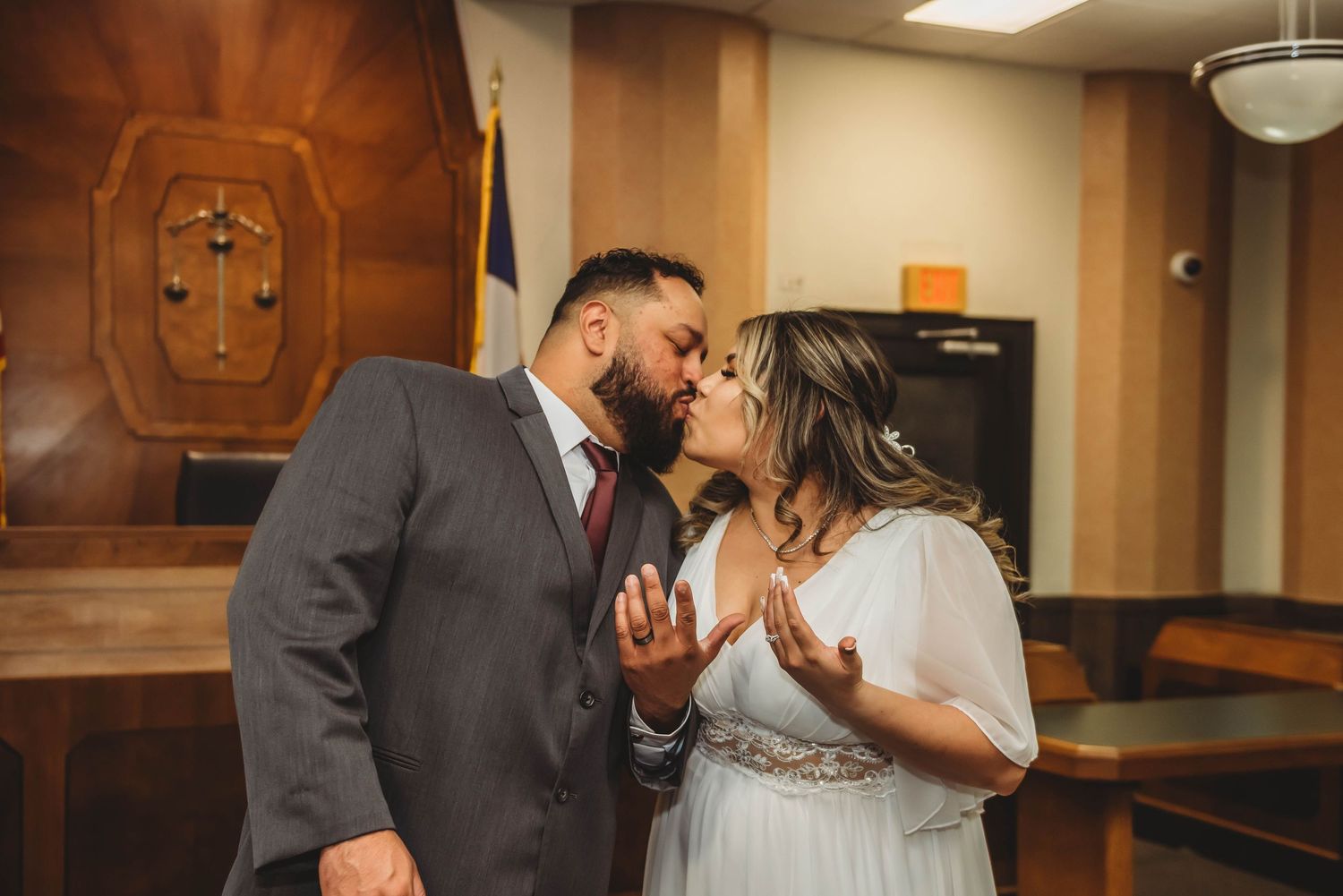 A newlywed couple shares romantic moments in various poses during their wedding celebration in an indoor venue.