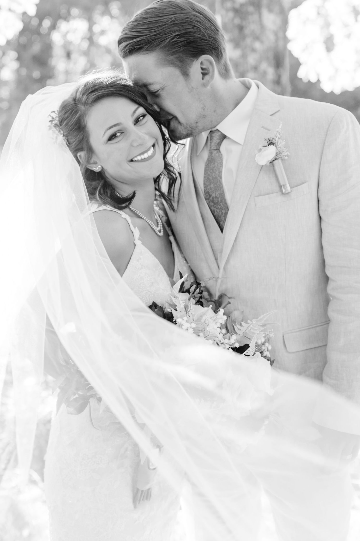 Black and white wedding photos showing romantic moments between newlyweds in an outdoor setting.