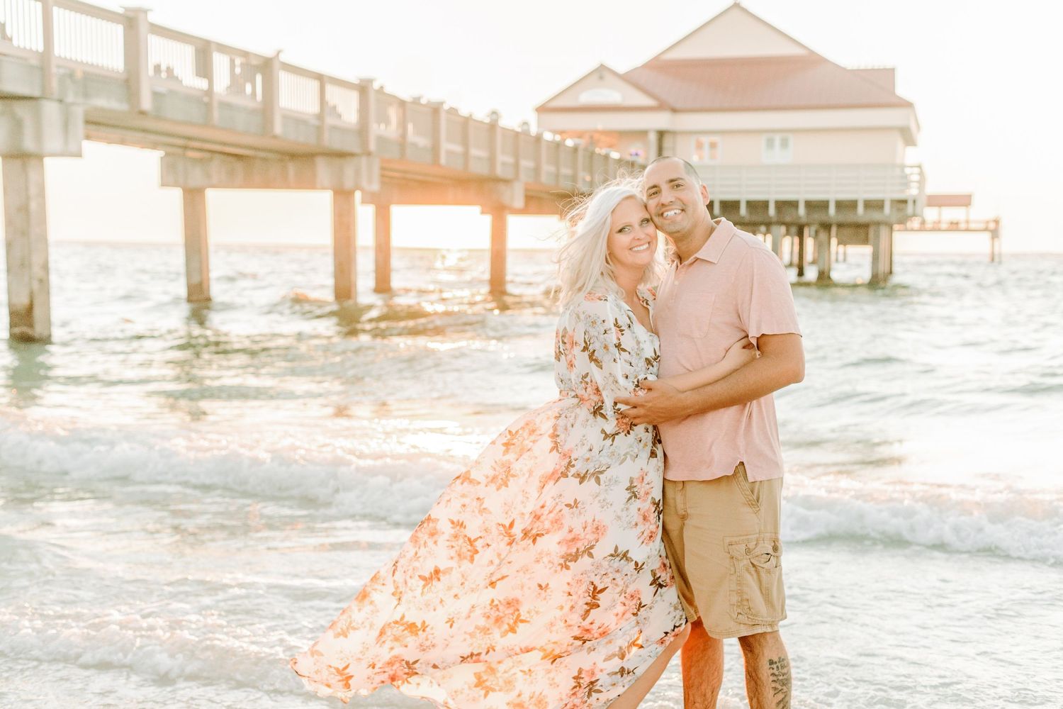 Romantic beachside portraits with peach and coral tones at golden hour.
