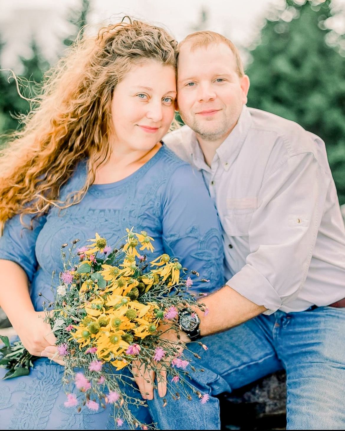 Casual outdoor couple portrait with bright yellow wildflower bouquet.