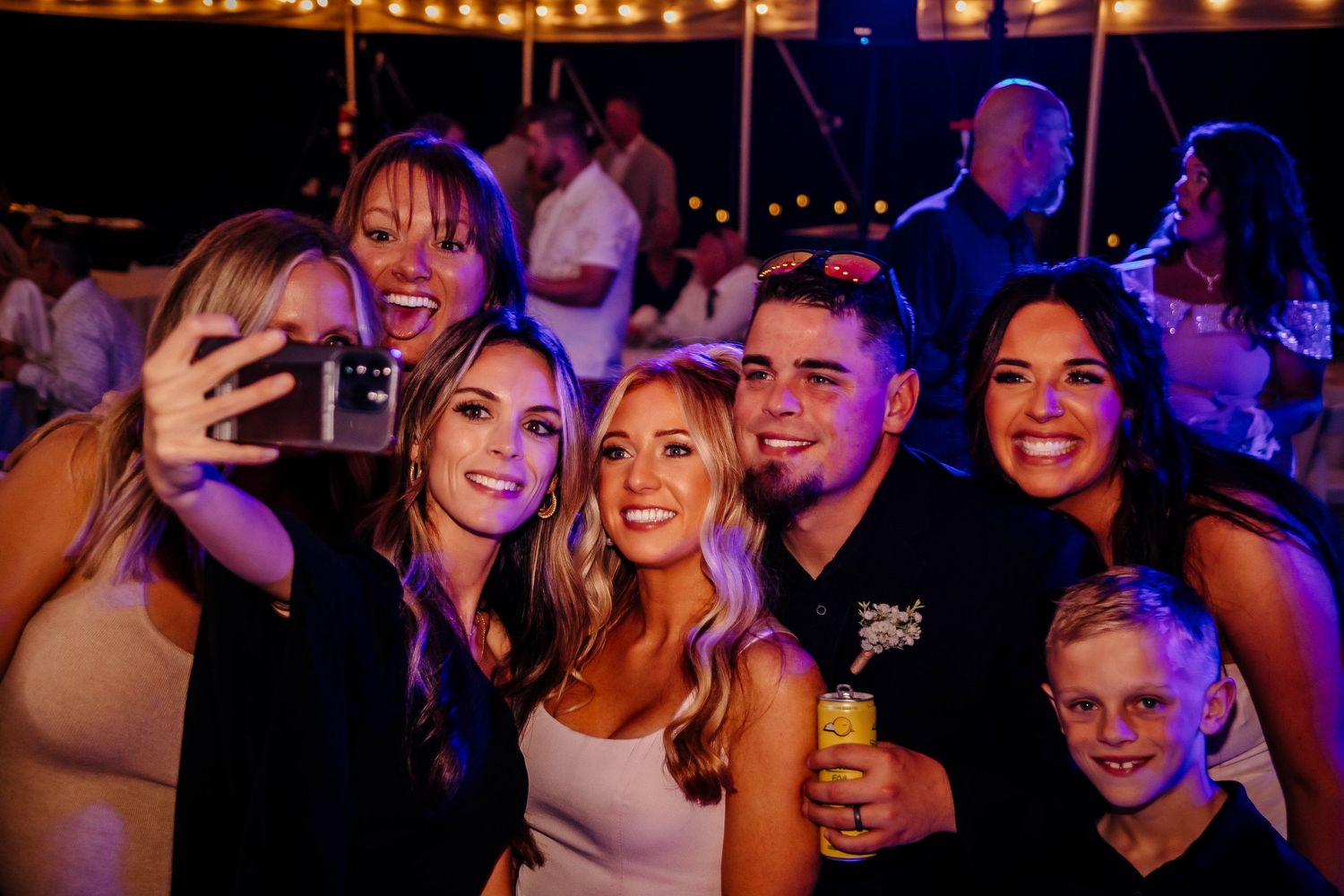 A group of friends enjoying a night out at a dimly lit venue with colorful lights in the background.