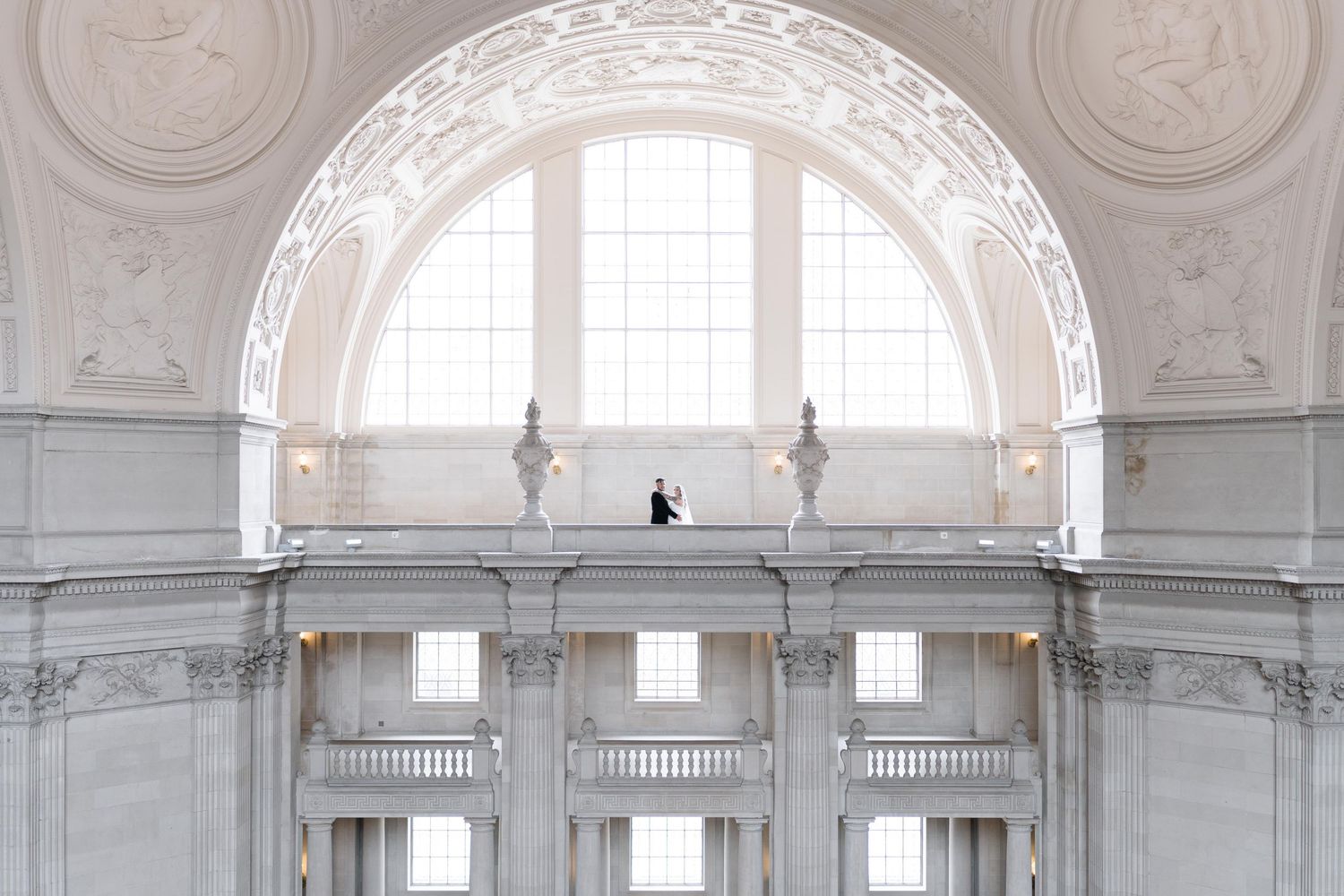 Ornate white baroque church interior with arched windows and decorative plasterwork on the ceiling and walls.
