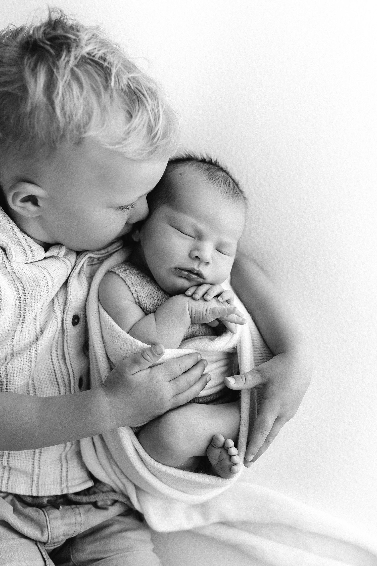 Black and white series of intimate close-up photos showing tender bonding moments between parent and baby.