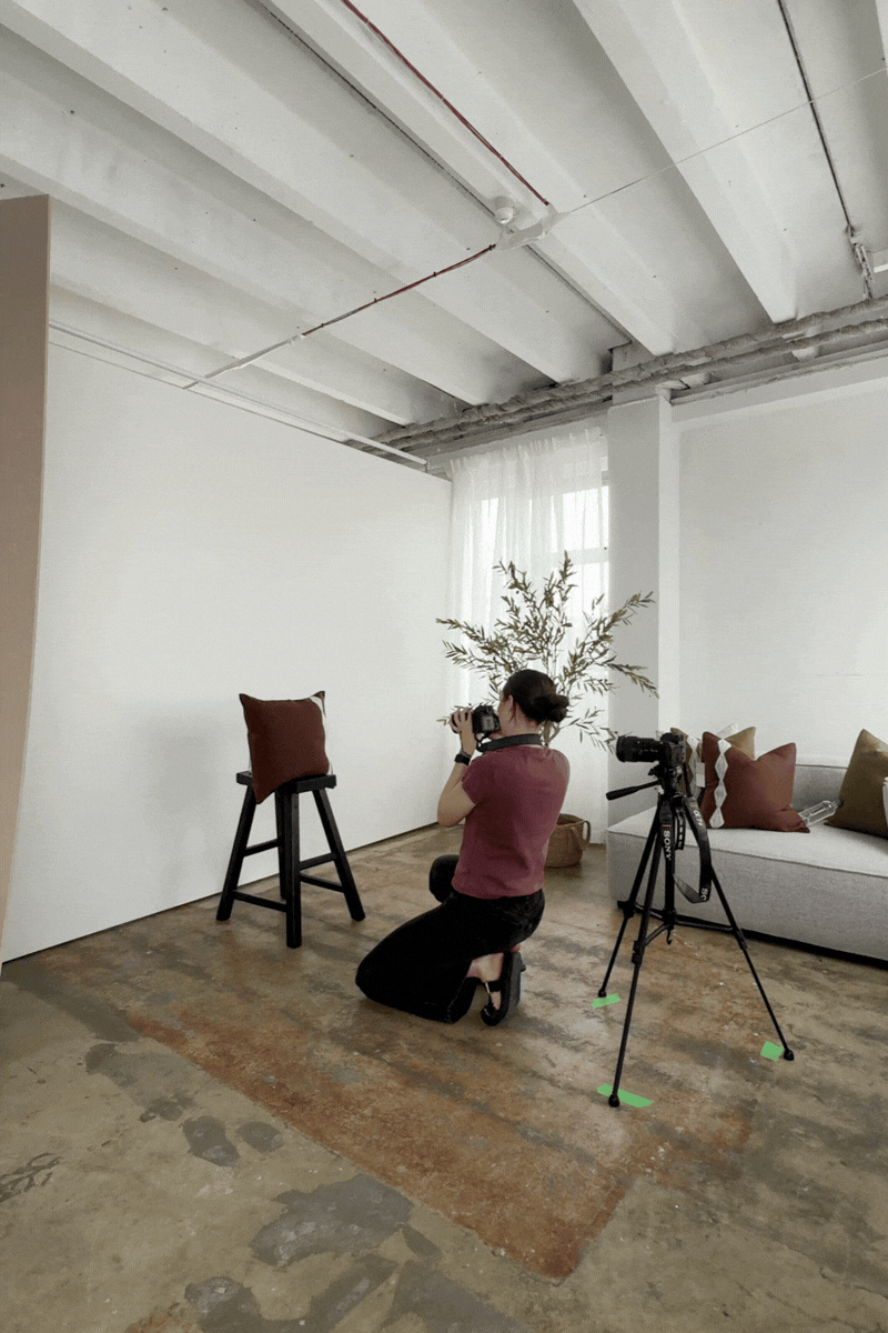 A sequence of photos showing a photographer setting up equipment in a minimalist white studio space with concrete floors.