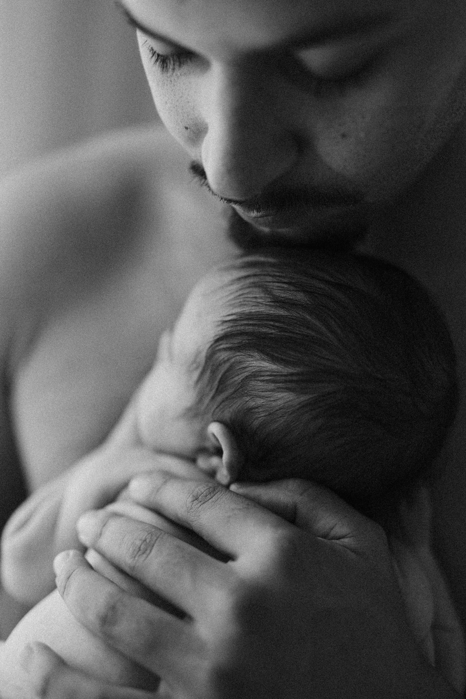 Black and white close-up photos showing adorable baby's facial features and gentle touch in sequential frames.