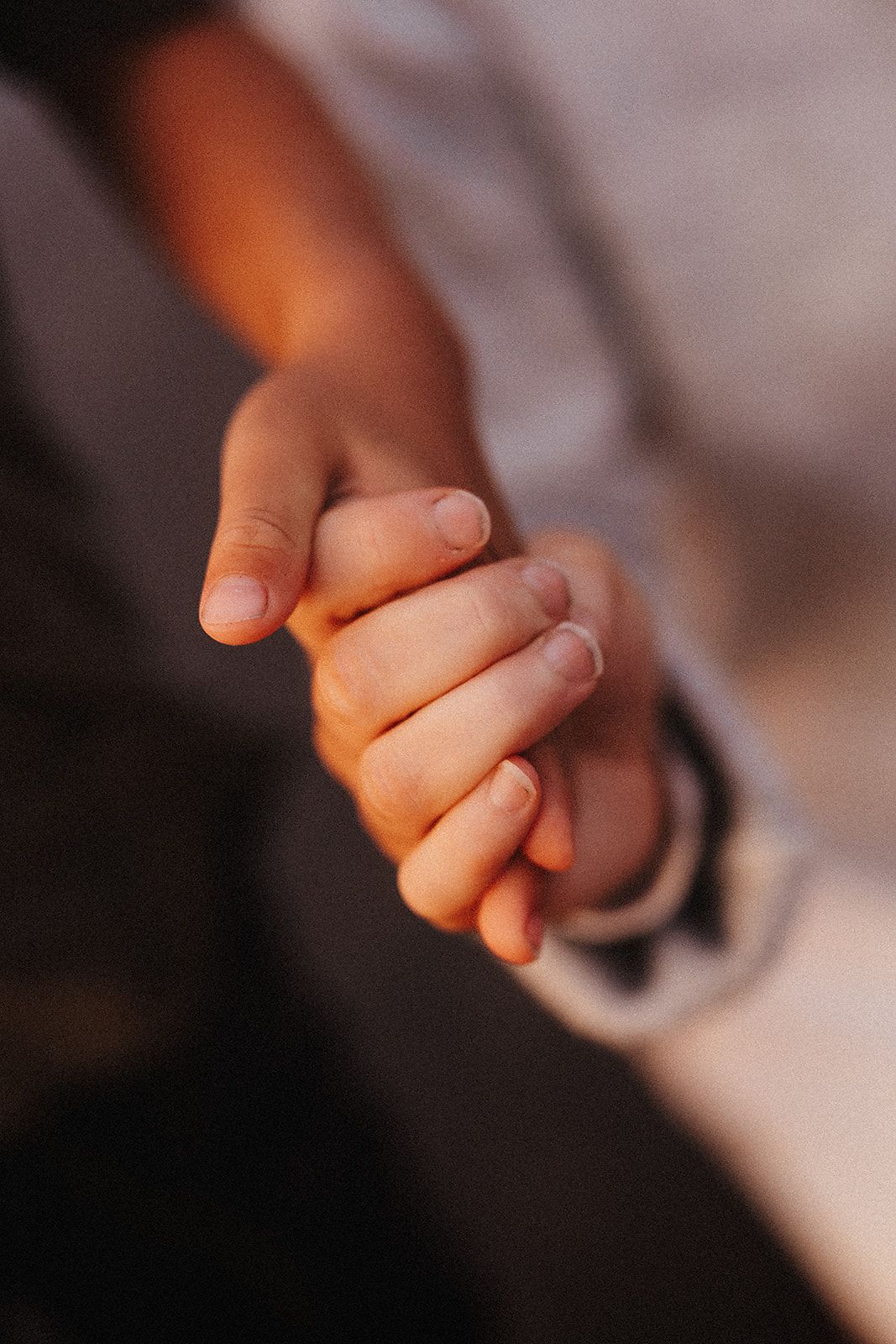 Close-up photo series showing hands holding and interlocking fingers in warm lighting.