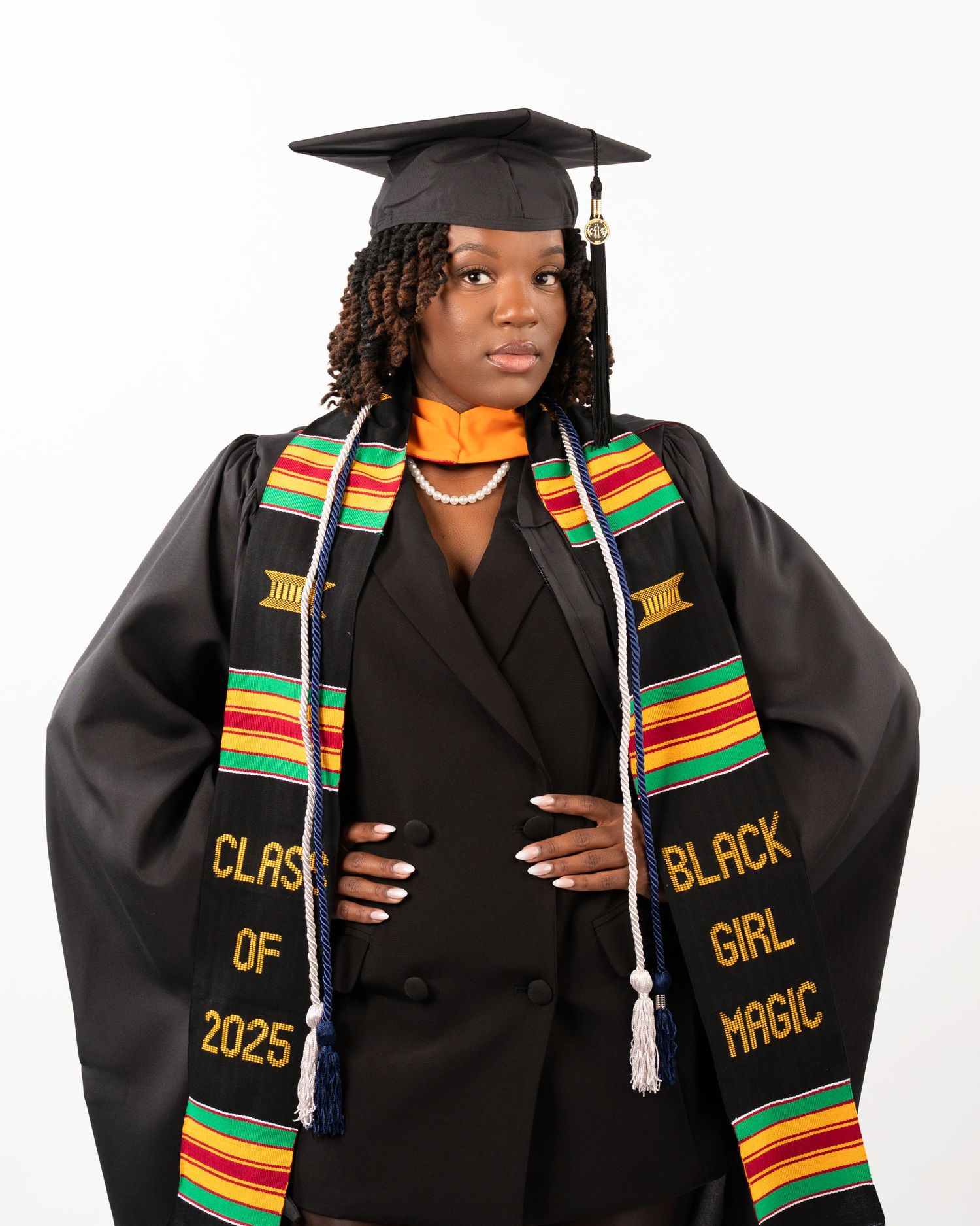 Graduate in cap and gown with Kente stole reading Class of 2025 and Black Girl Magic.