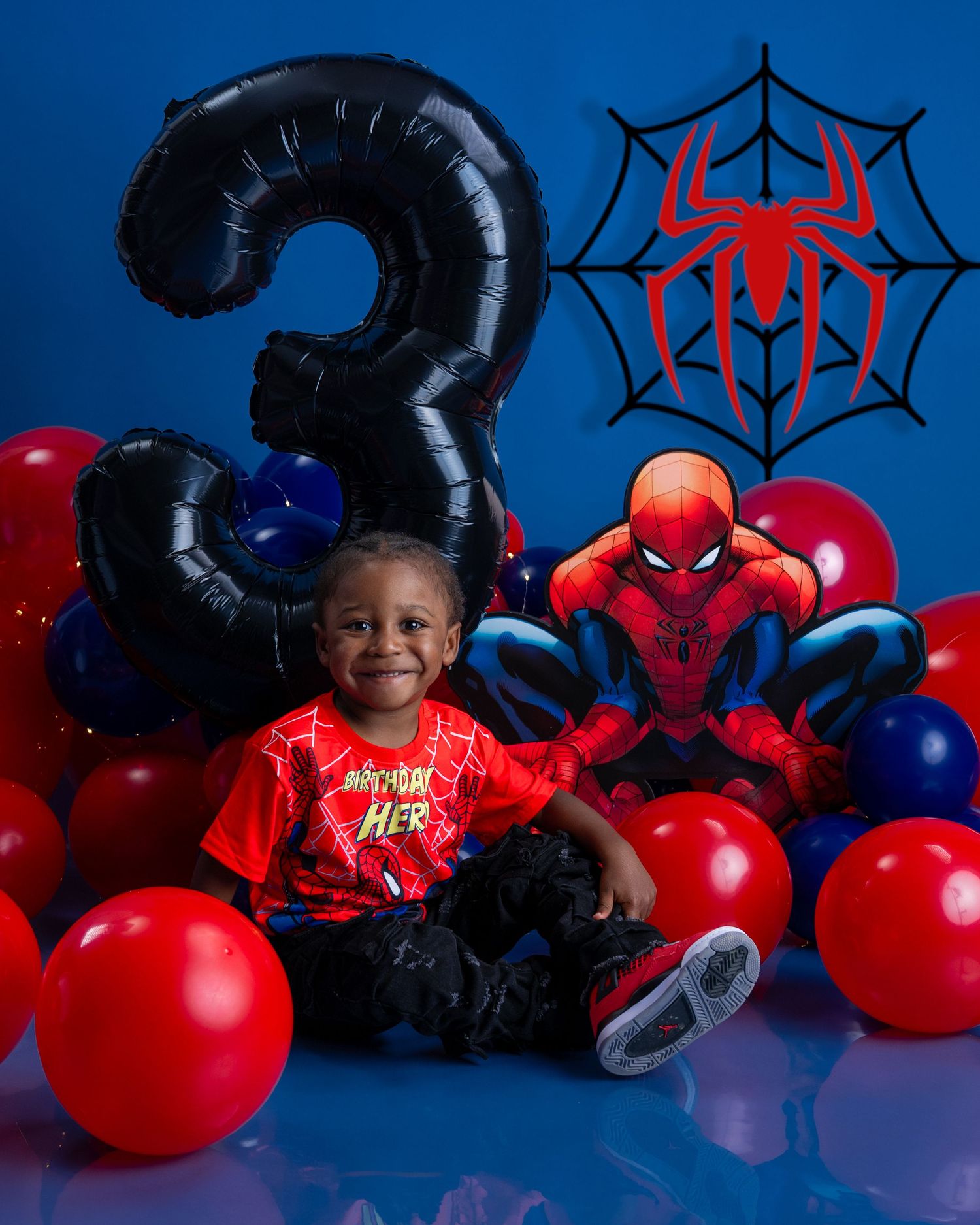 Toddler celebrates 3rd birthday with Spider-Man theme, balloons, and number 3 balloon.