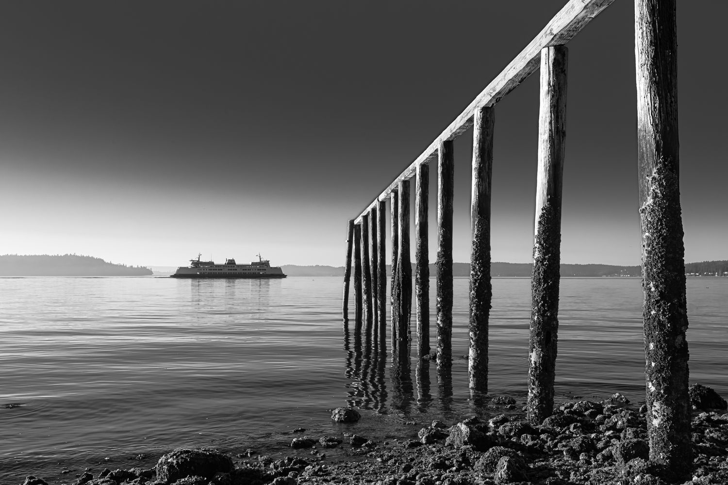 Black and white fine art photograph of a pier extending across calm water at South Beach.