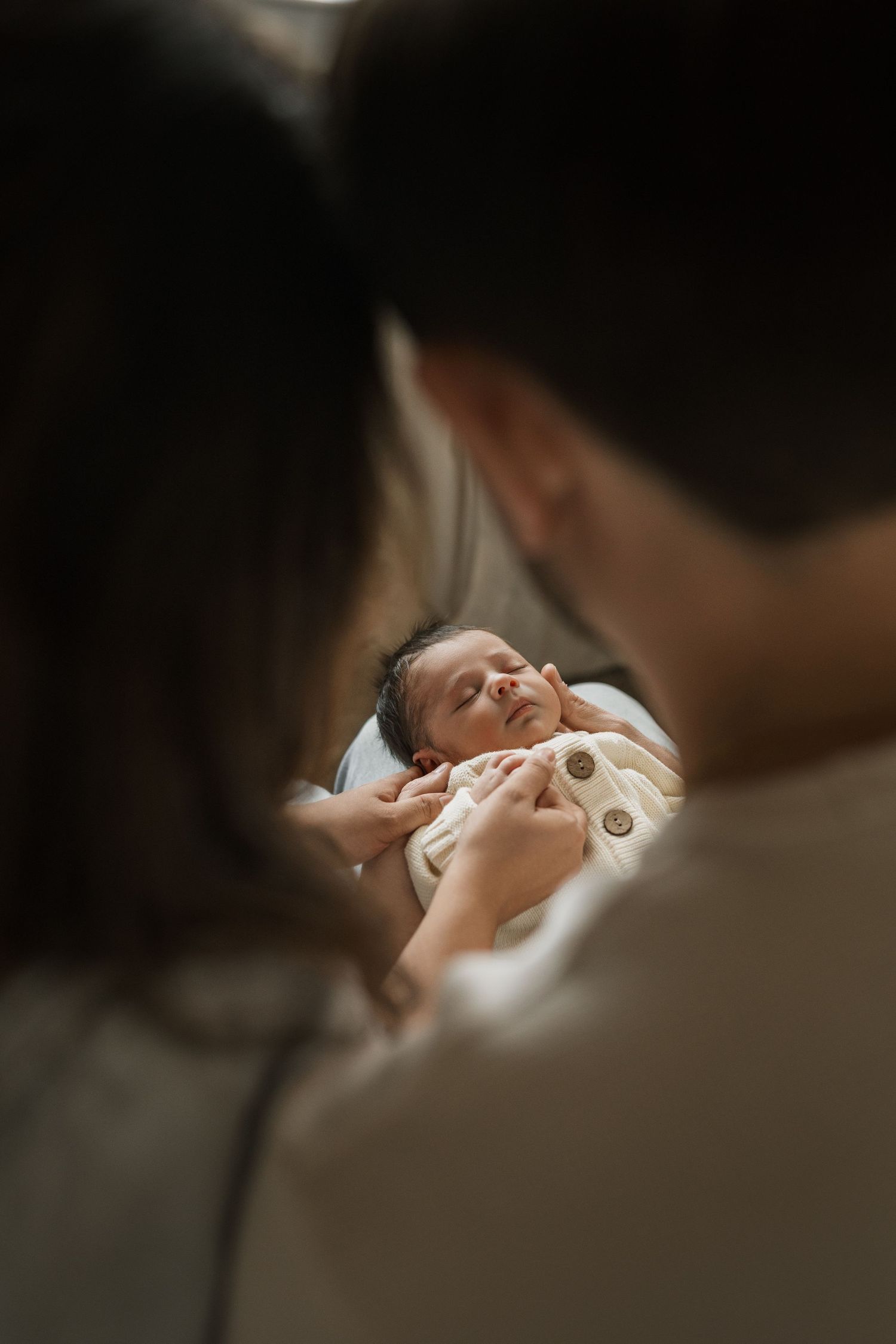 Intimate close-up shot of couple sharing tender moments in bed with soft lighting and shallow depth of field.
