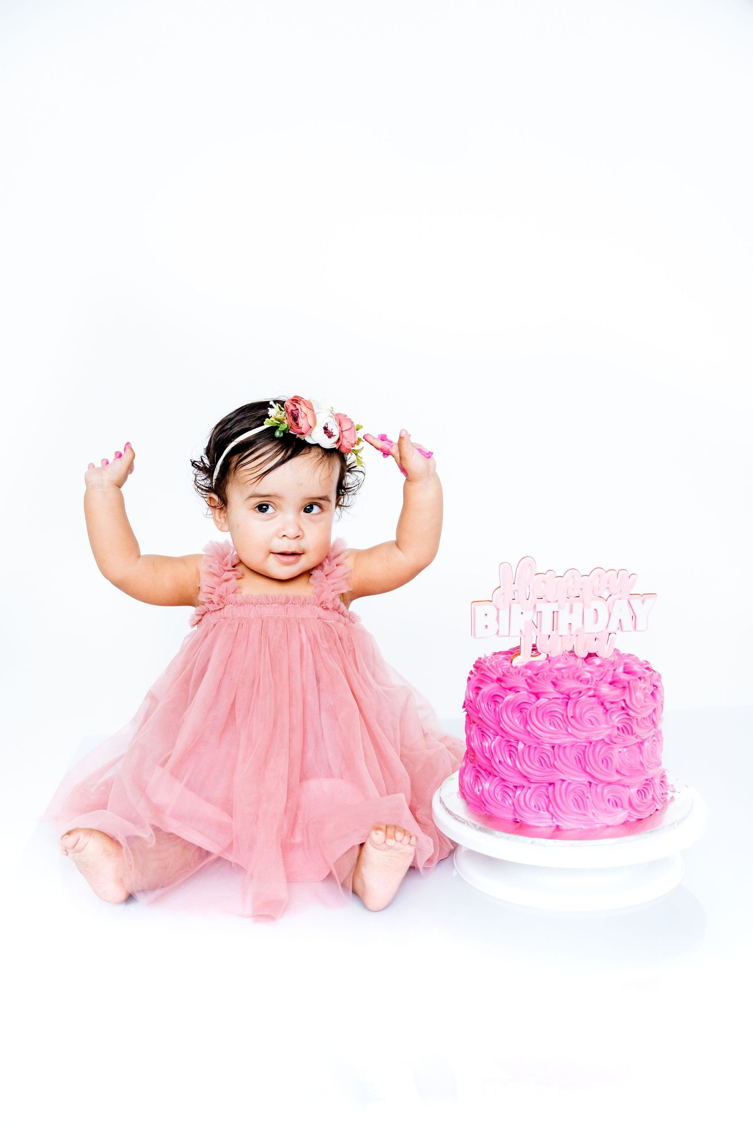 First birthday celebration with pink tulle dress and beautifully decorated rose cake.
