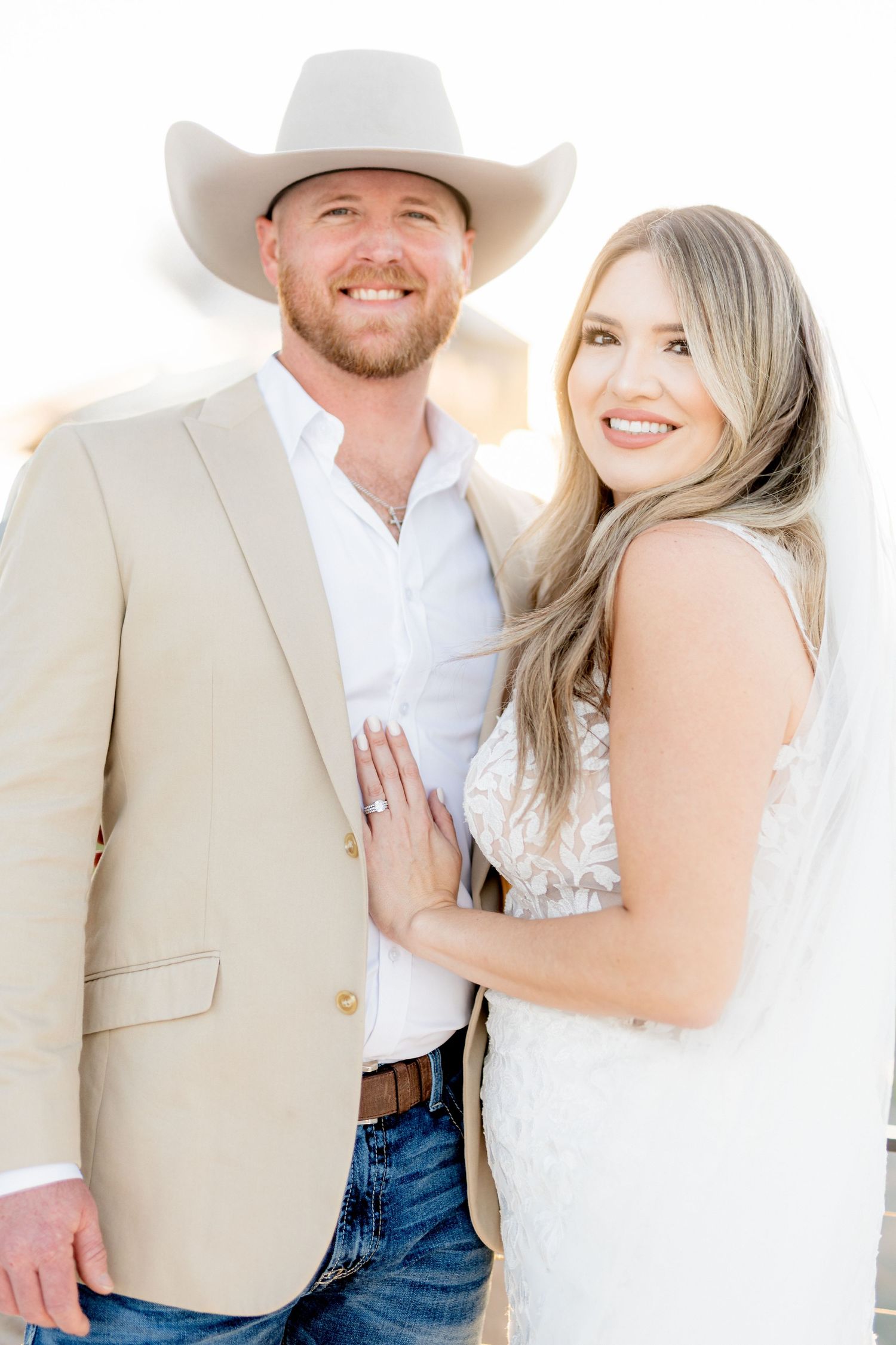 A country western themed wedding portrait featuring formal attire and a cowboy hat.